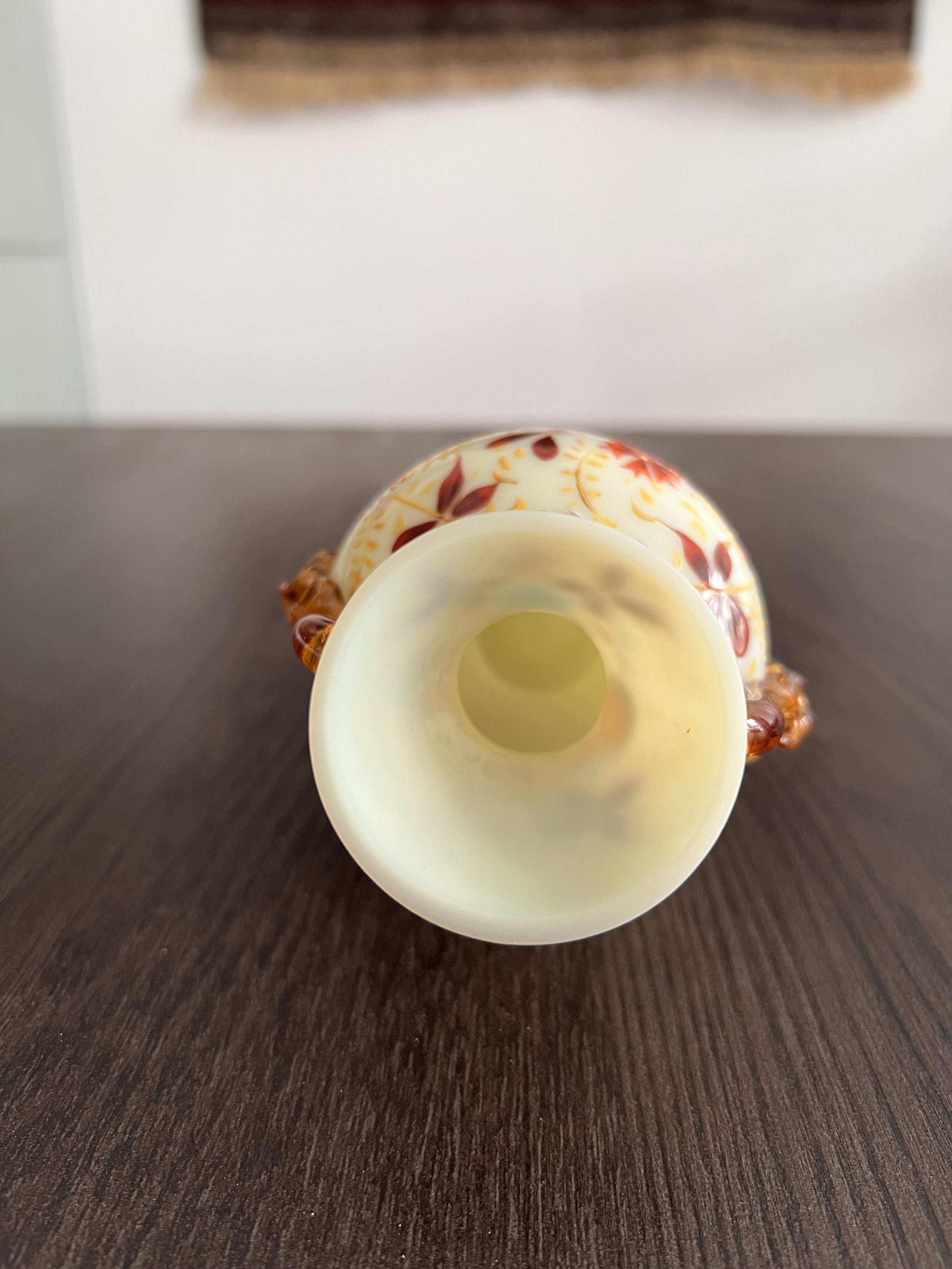 Antique ivory opaline glass vase with hand-painted enamel floral decoration, gilt accents, and applied amber glass handles, circa 1900.