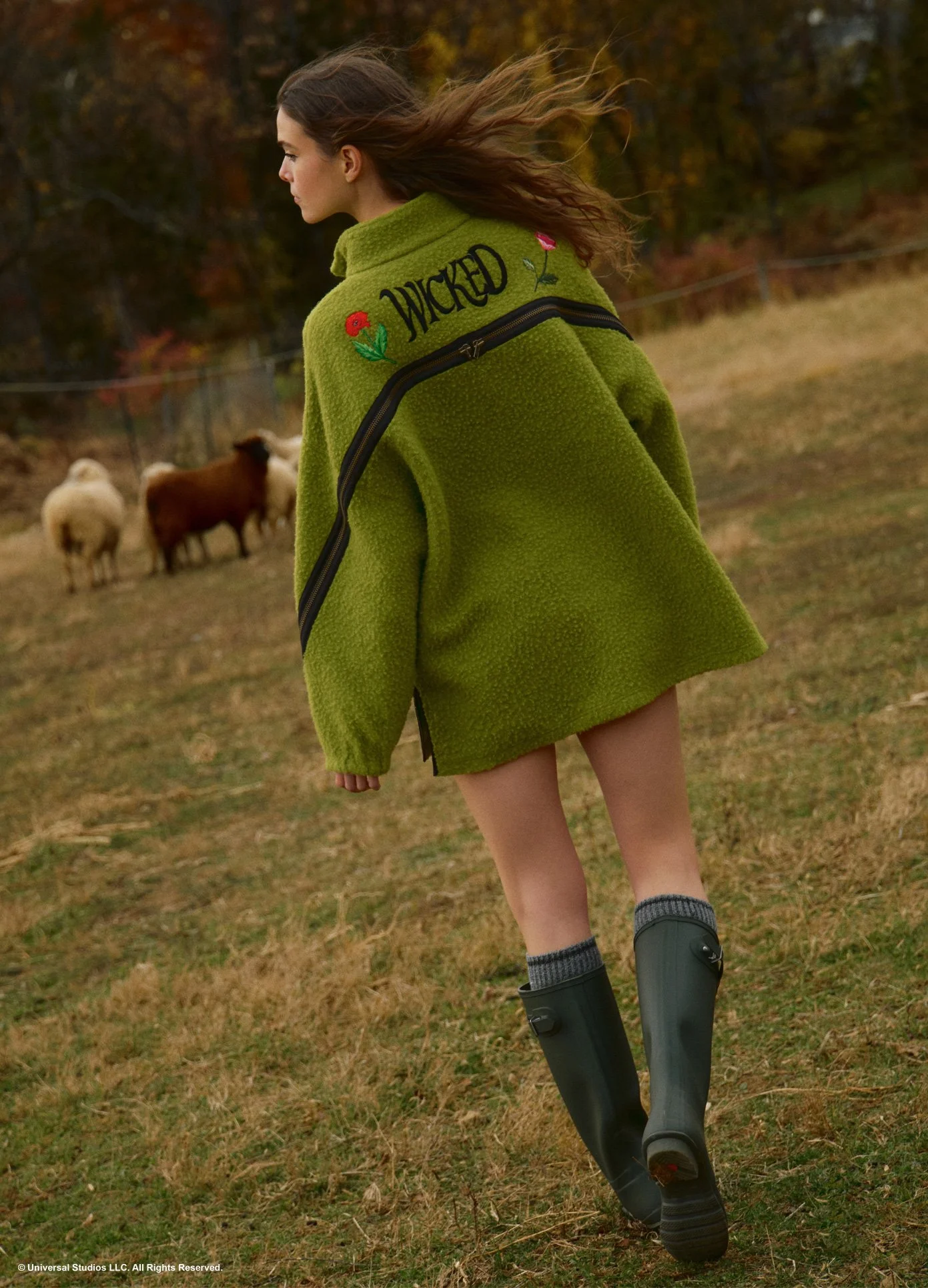 monse-wicked-collaboration-oz-varsity-fleece-in-green-on-model-walking-lifestyle-image.jpg