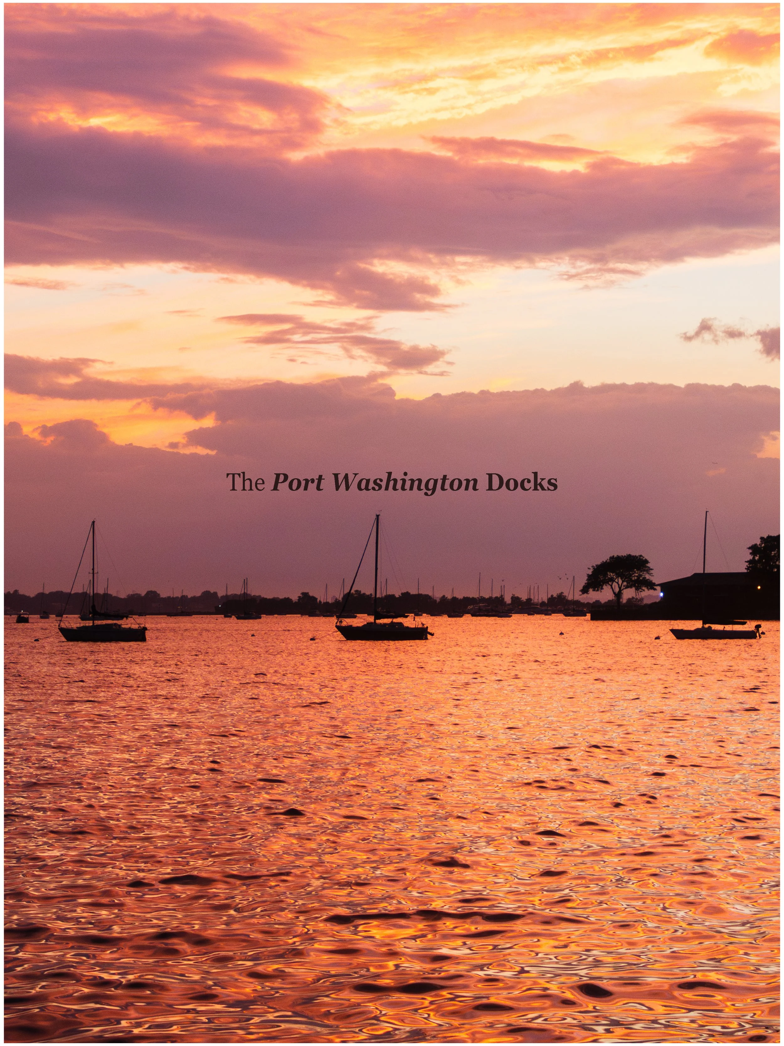 Sunset over the Port Washington Docks with sailboats on calm water