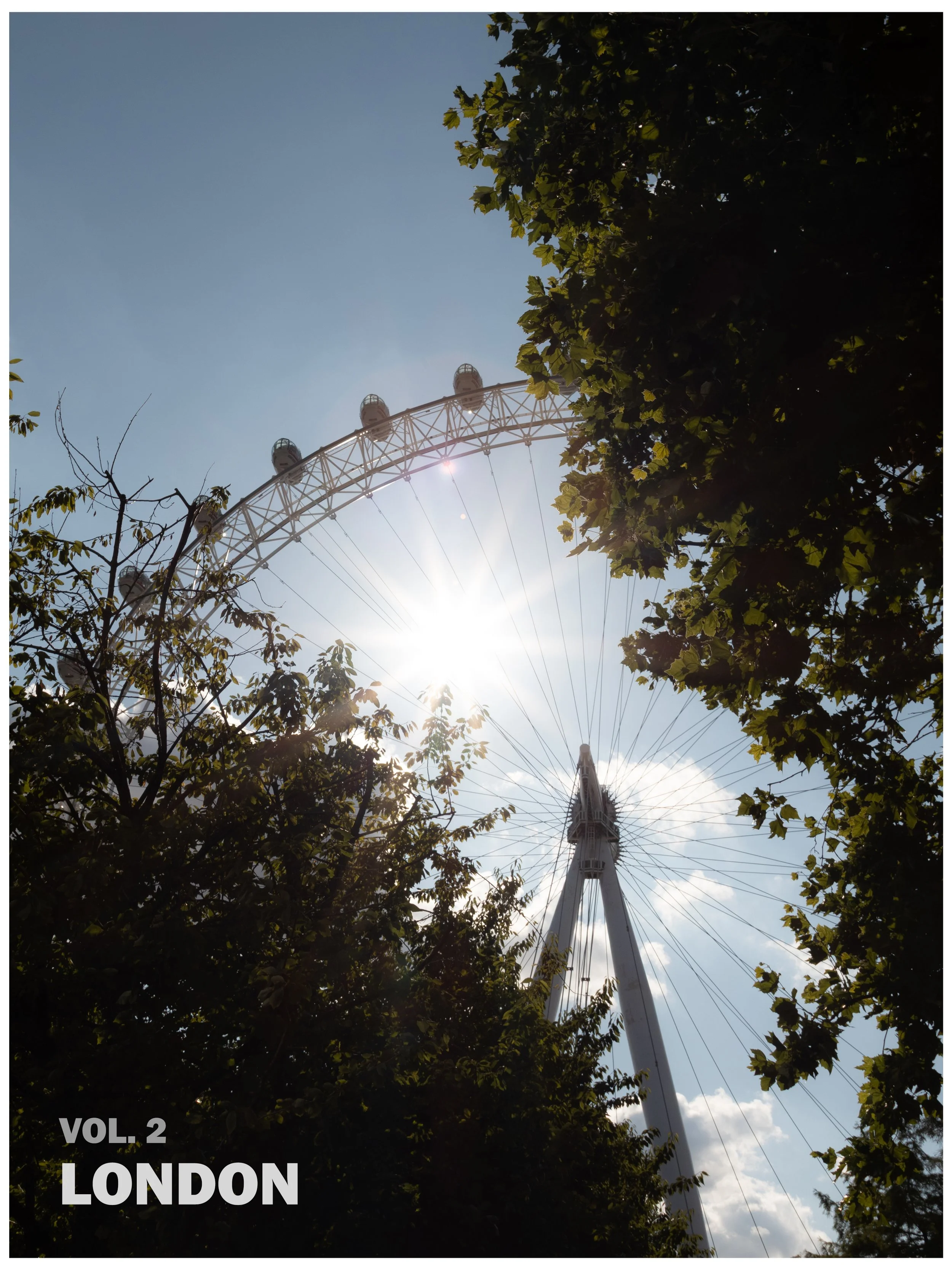 The London Eye Ferris wheel viewed from below with the sun shining brightly through the trees.