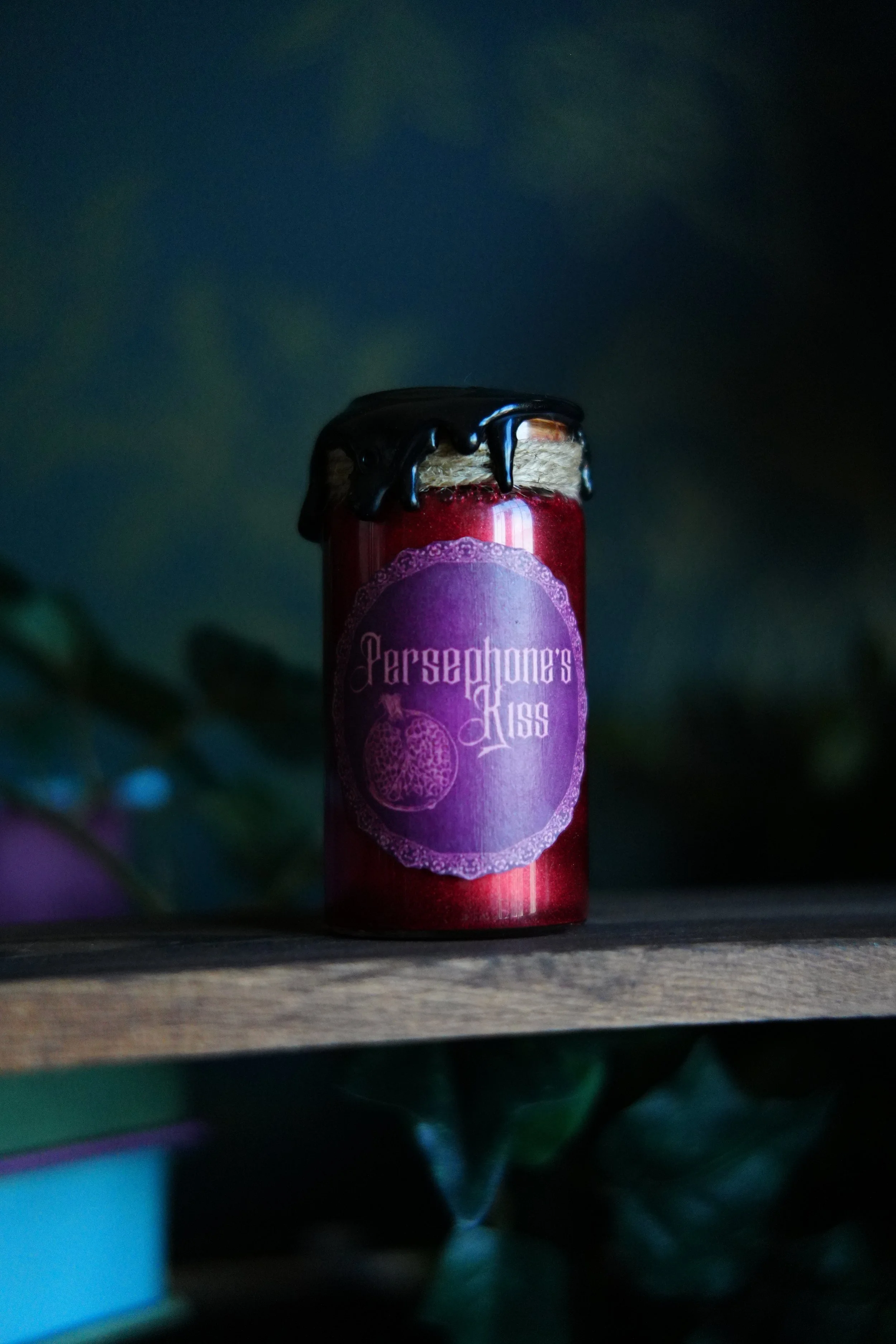Small, red decorative potion with a label that reads "Persephone's Kiss"