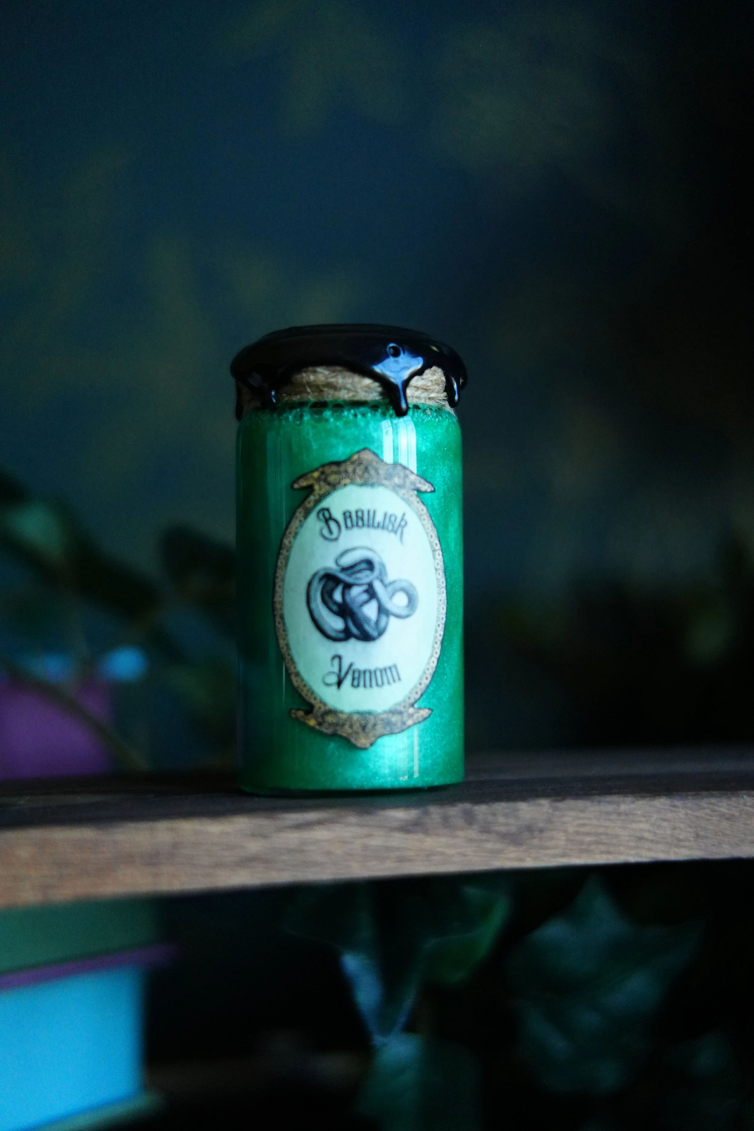Small, green decorative potion with a label that reads "Basilisk Venom"