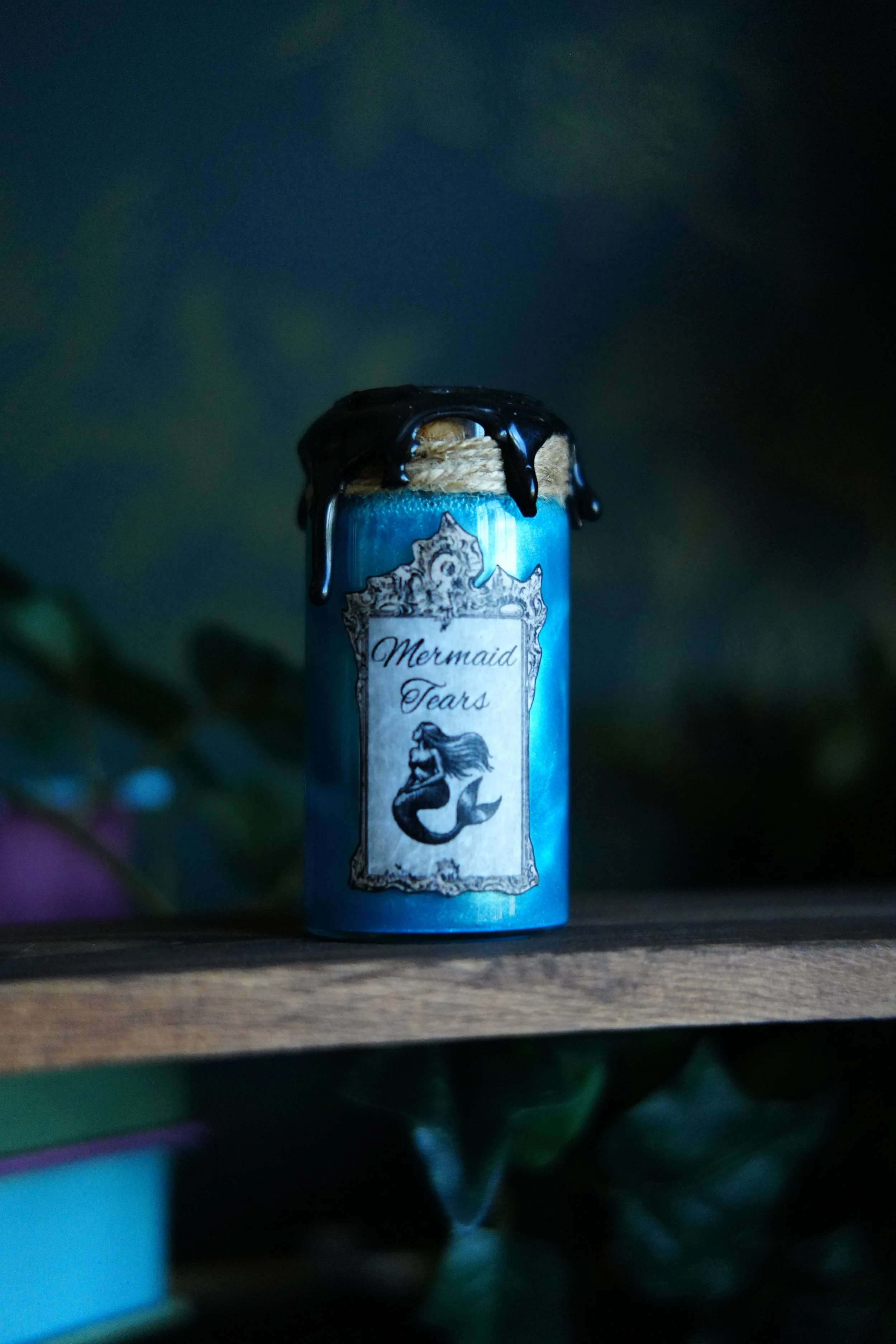 Small, blue decorative potion with a label that reads "Mermaid Tears"