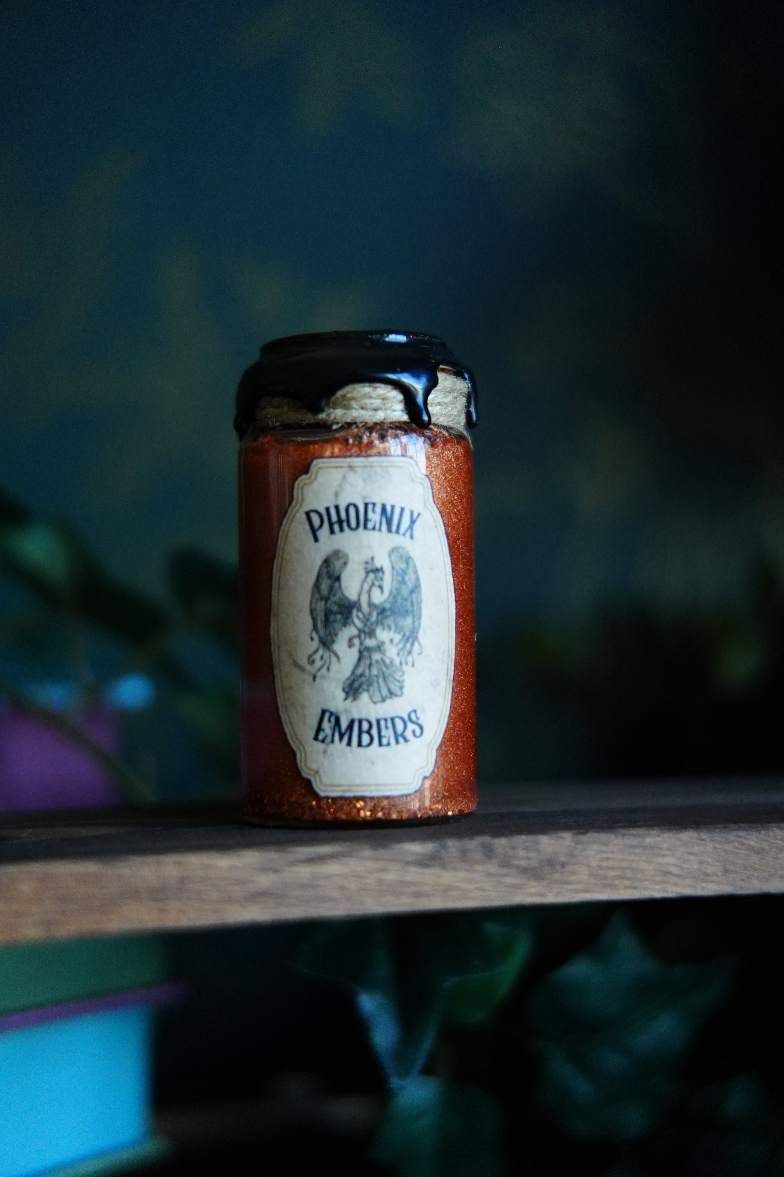 Small, red decorative potion with a label that reads "Phoenix Embers"