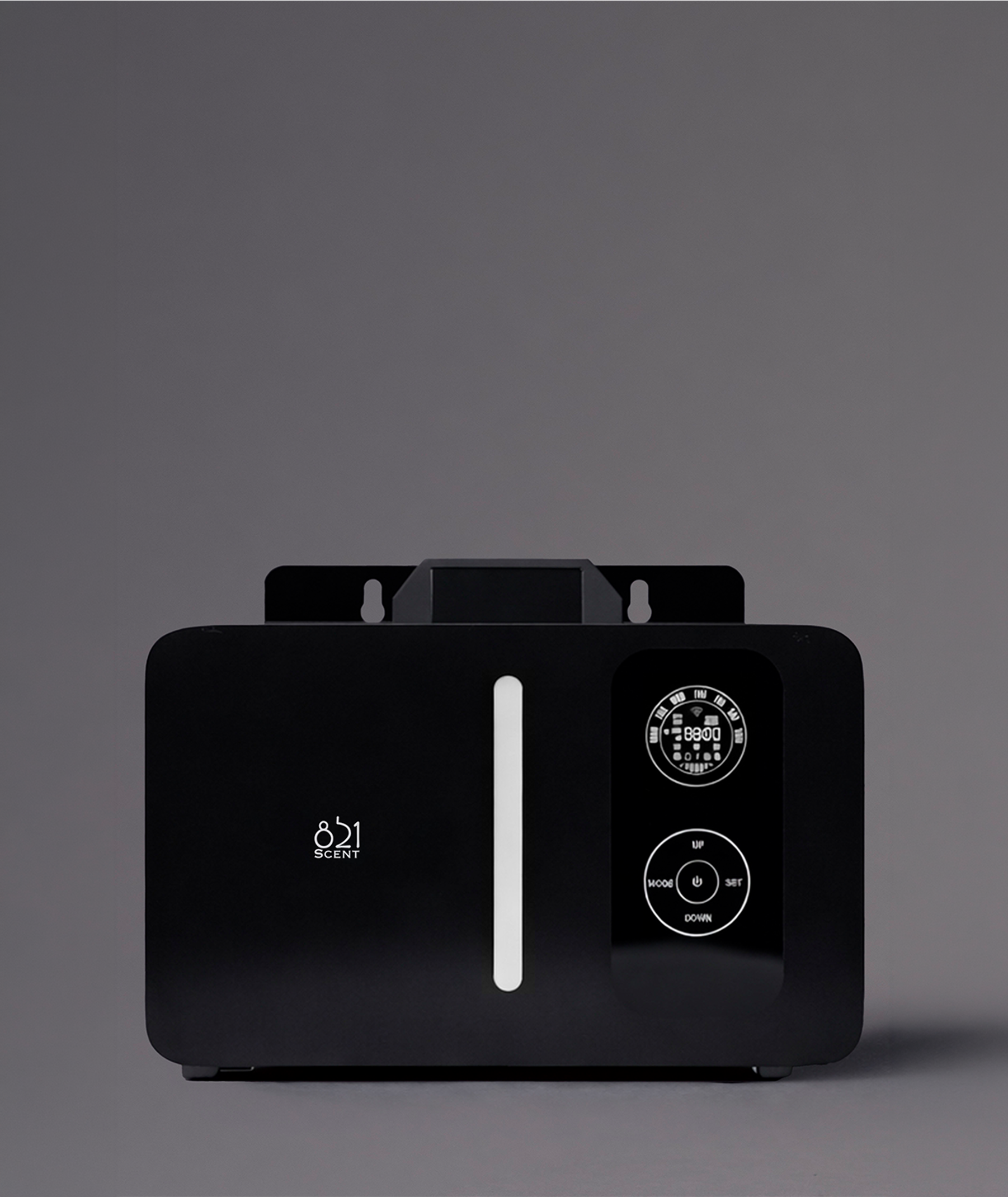 A digital device with a display showing the number 851 and the word 'SCENT' underneath, surrounded by a black frame with various control buttons and a circular dial, against a plain gray background.