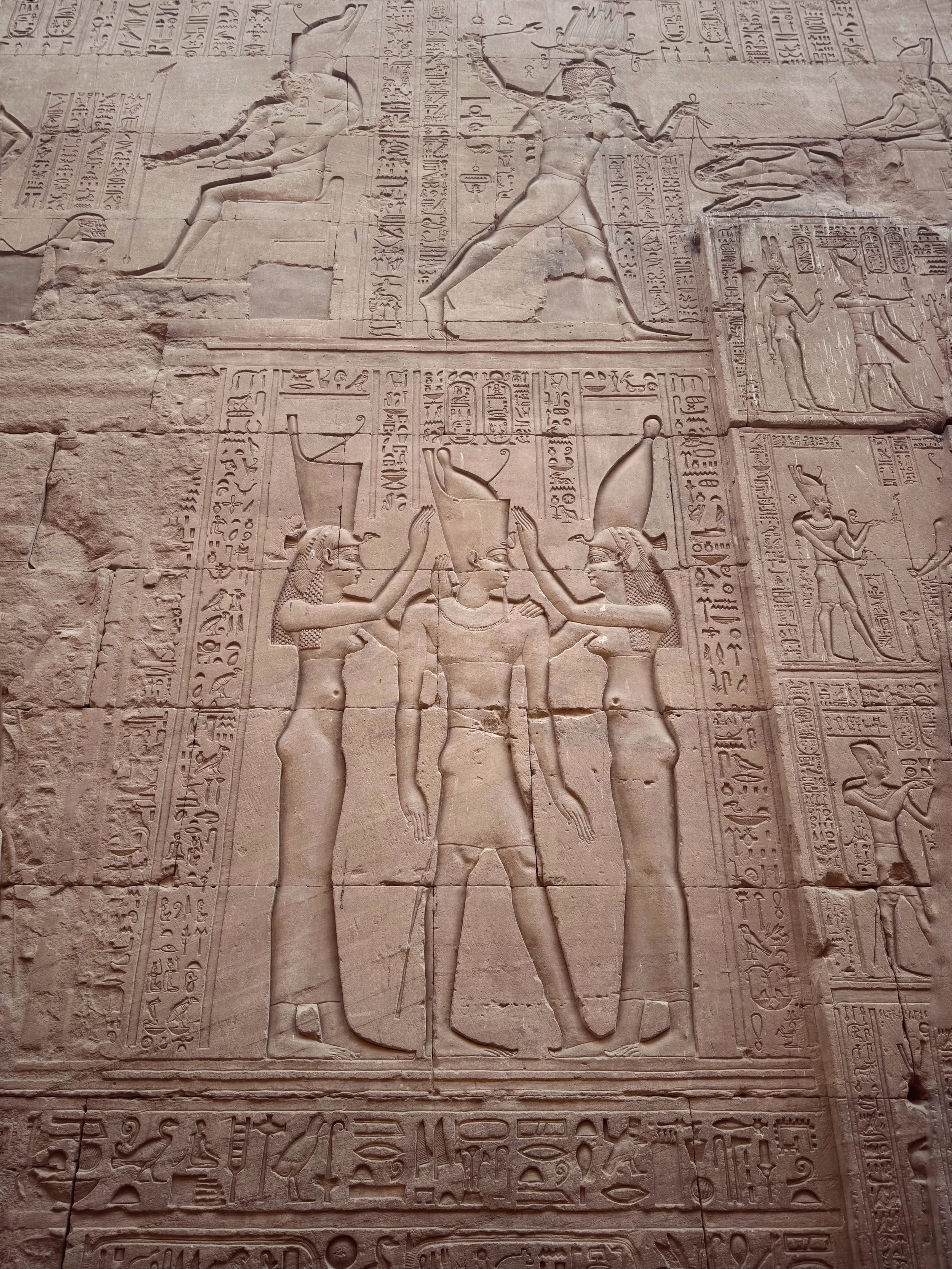 Ancient Egyptian carved stone relief showing rulers and gods, hieroglyphics, and symbolic imagery.