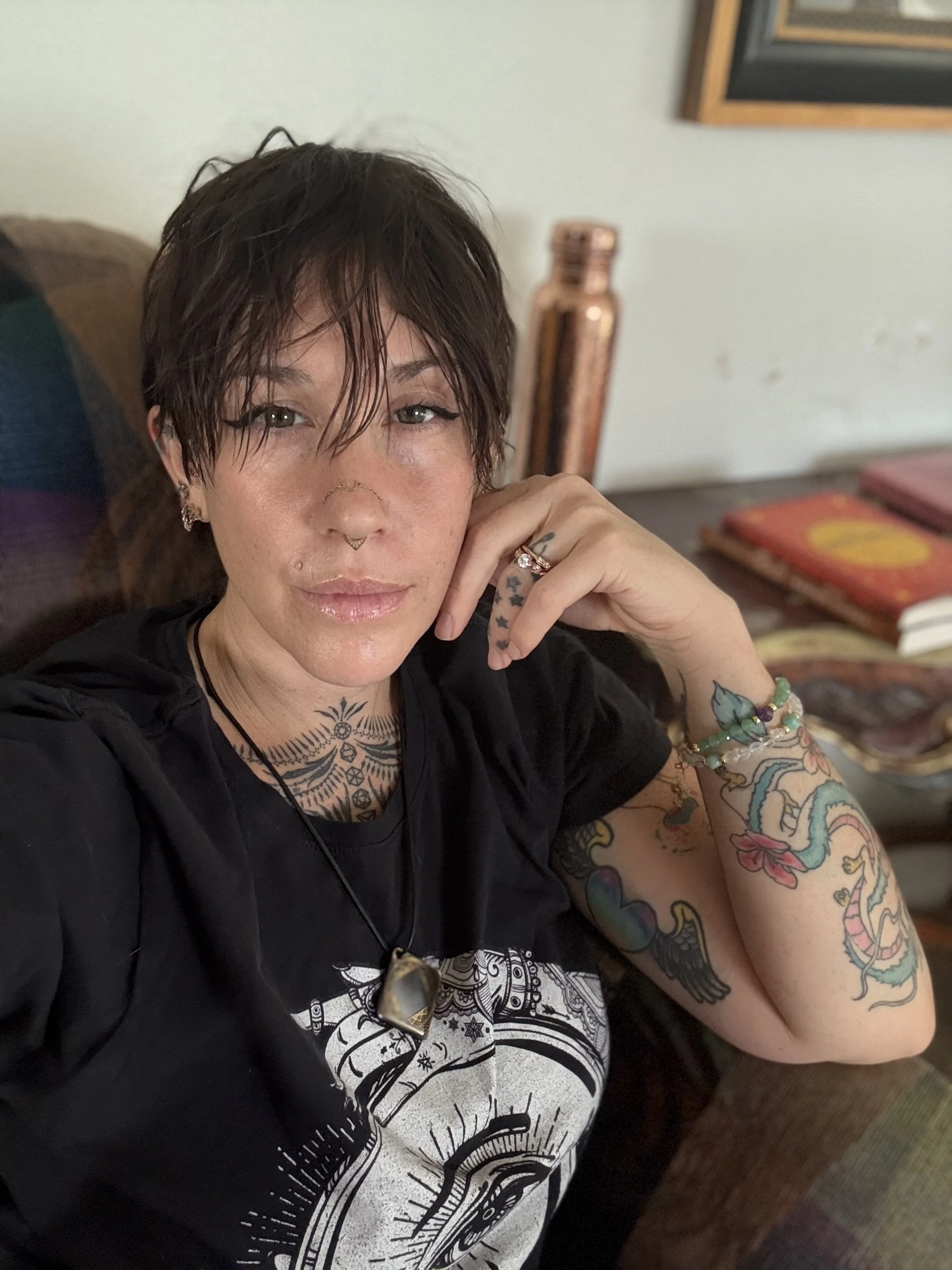 A graphic design promoting Loveland Community Yoga with a background of stylized mountain ranges in shades of gray and white. The center features a white outline circle, with a lotus flower at the bottom, and the text 'YOGA' in bold letters. Above, it reads 'Loveland Community,' and below, it says 'MOVE BREATHE CONNECT'.