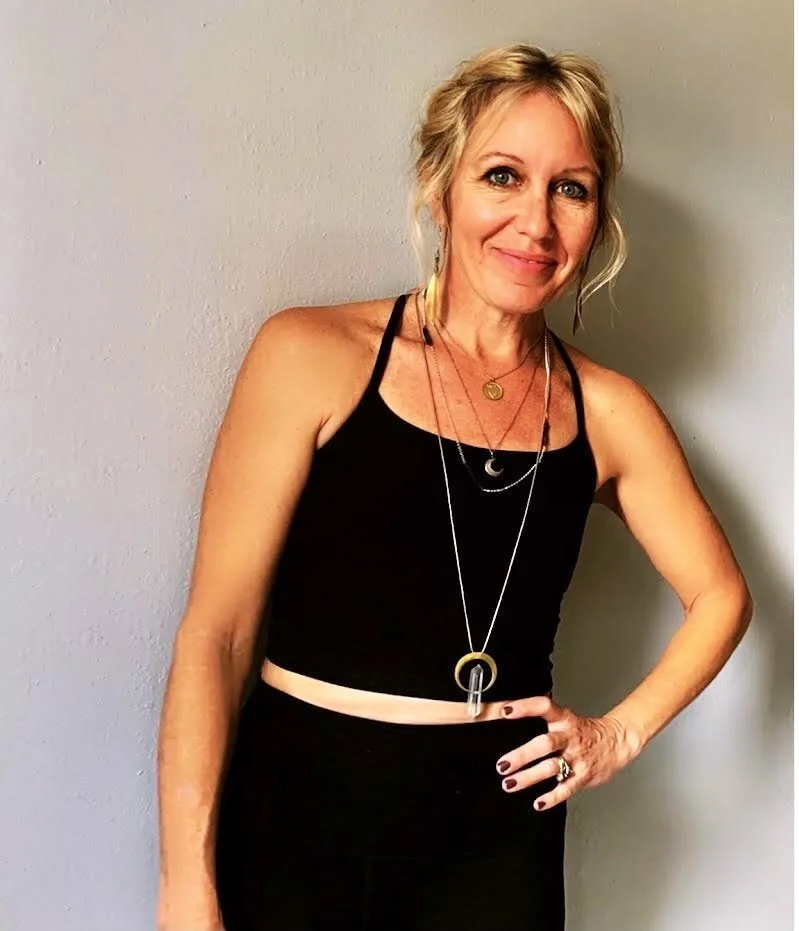 A graphic design featuring mountains in shades of gray and white with the text 'Loveland Community Yoga' and a lotus flower icon, along with the slogan 'Move Breathe Connect'.