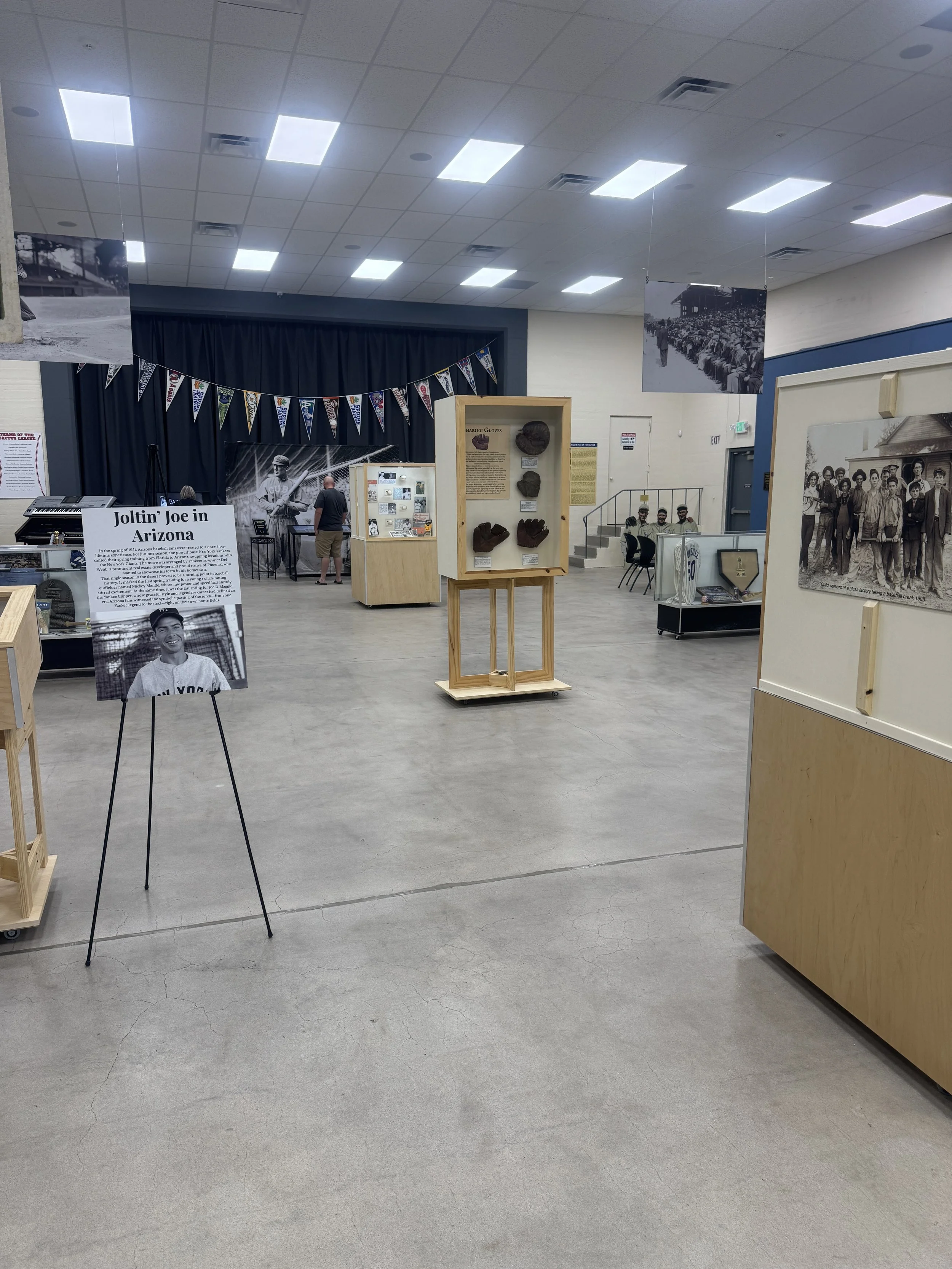 Exhibit in a museum featuring black and white photographs, historical artifacts, and informational displays about baseball history and African American contributions.