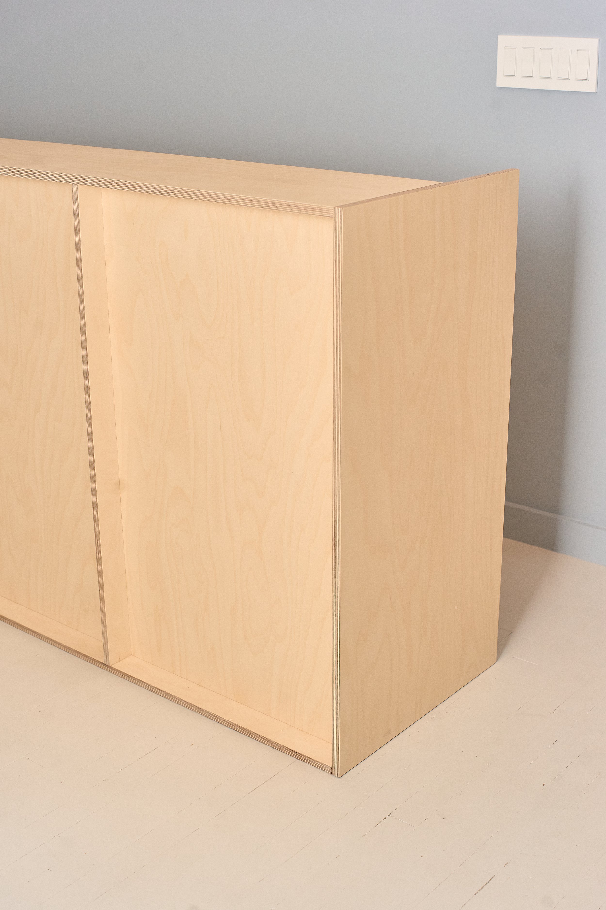 Full view of custom plywood reception desk in completed space.