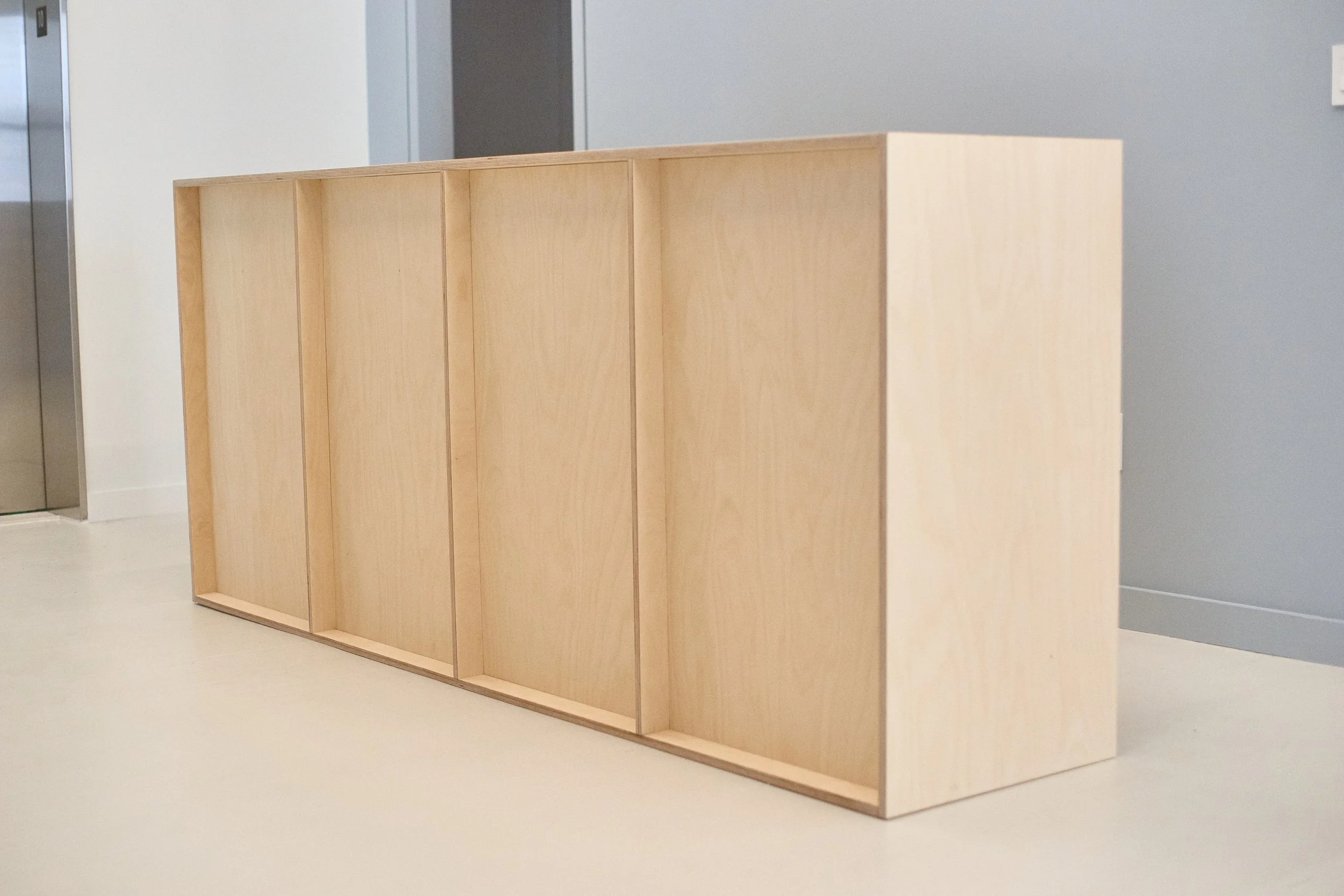 Custom plywood reception desk for commercial space by Derek Designs.