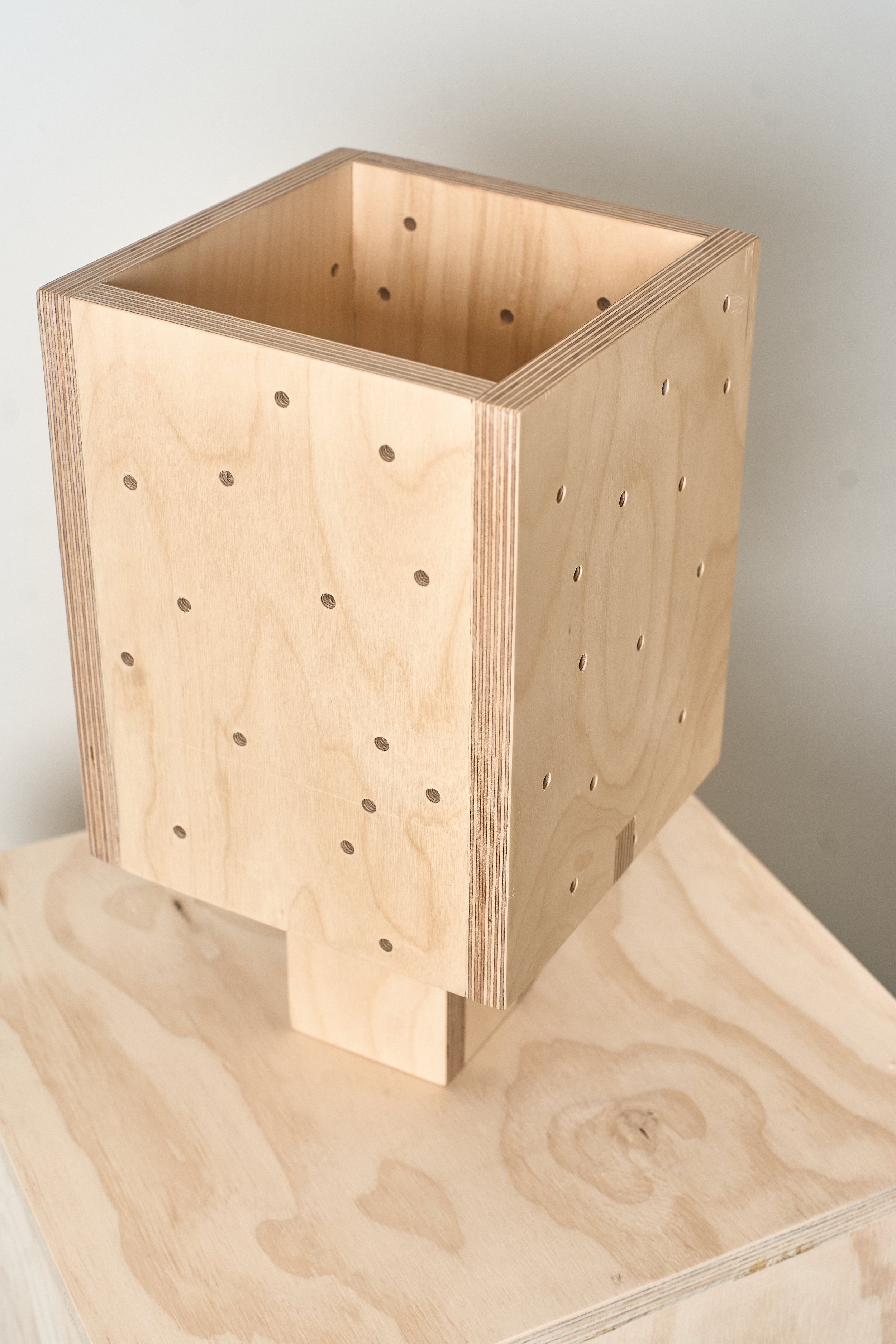 Plywood table lamp detail showing the layered wood edges and geometric construction.