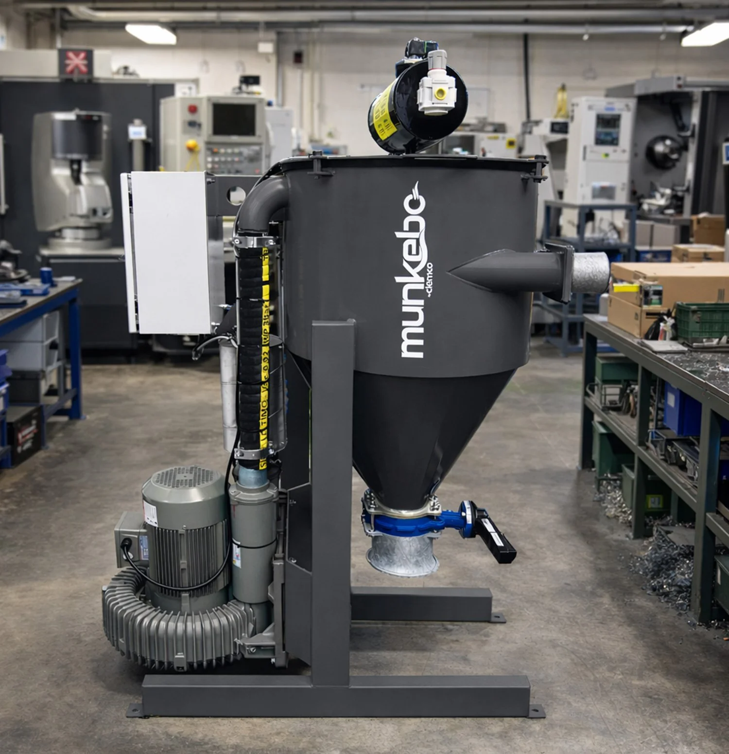 A MB-220 suction unit labelled 'munkebo' in a manufacturing facility with workbenches and equipment in the background.
