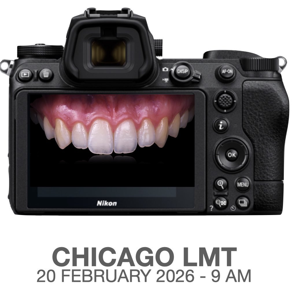 A man with dark hair and a beard, wearing a white shirt and black tie, giving a presentation with a microphone headset.
