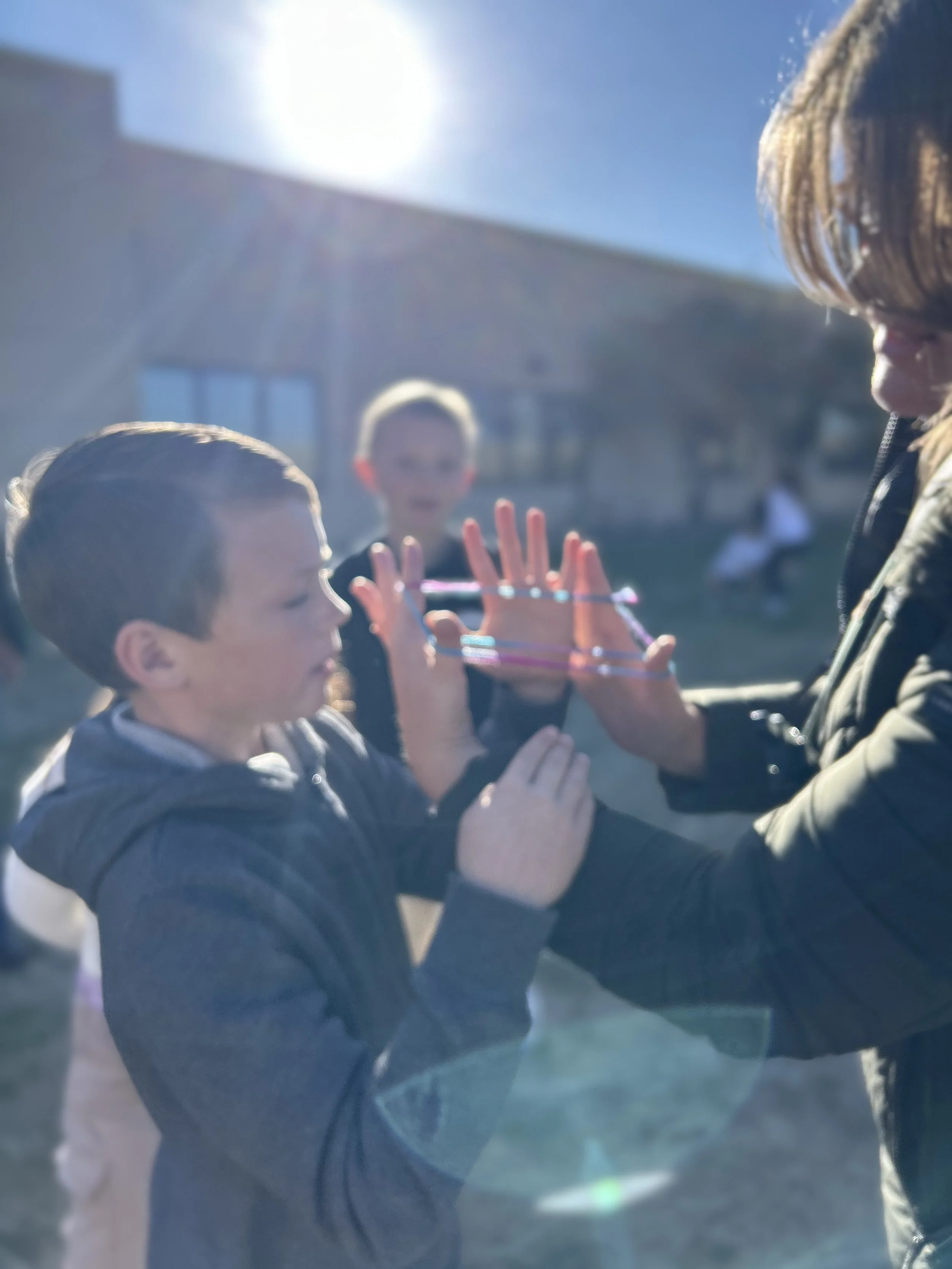 Teacher Helping Students with Yarn games at recess