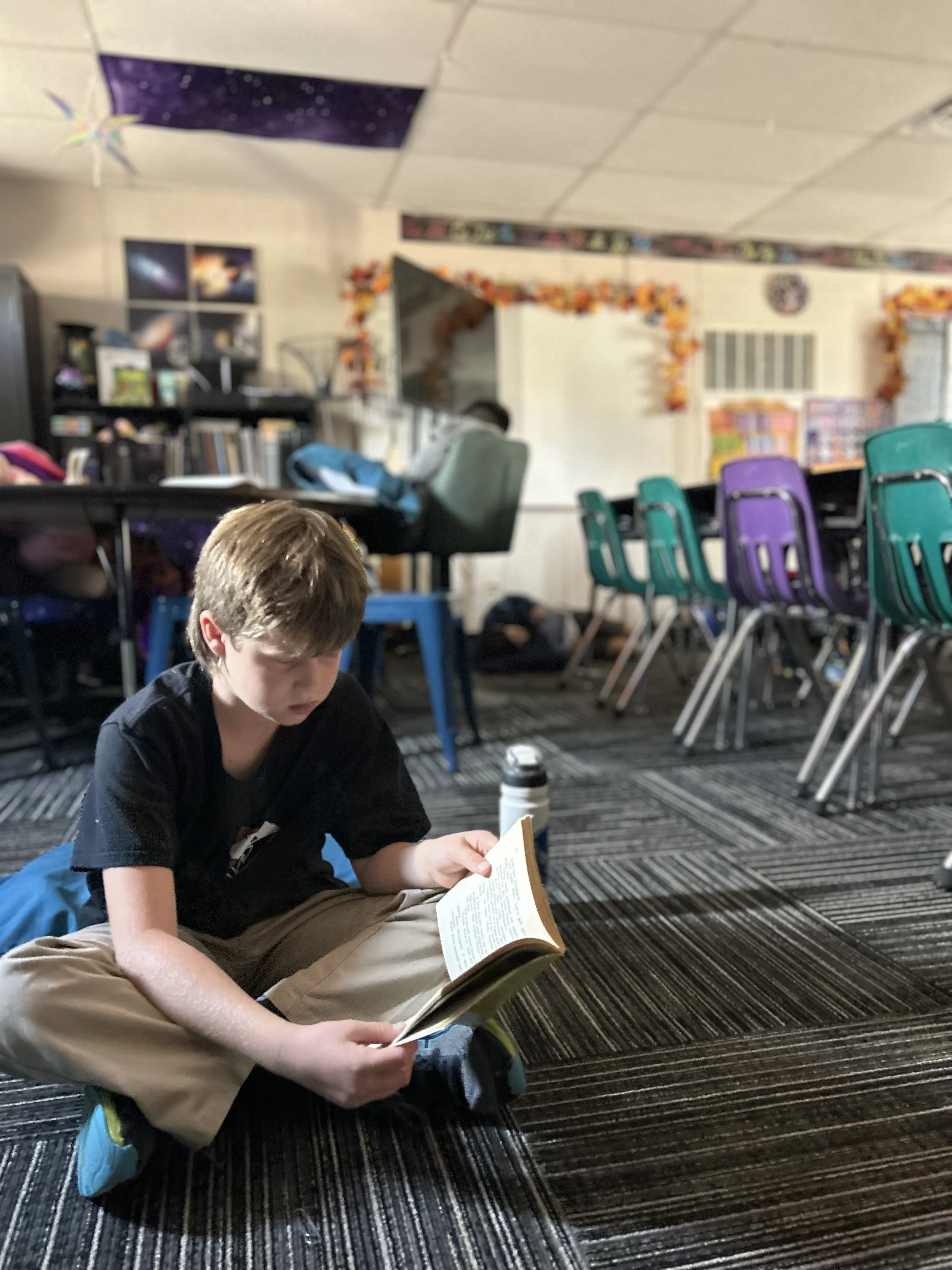 Student Reading a book in his classroom