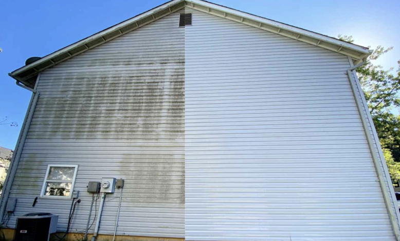 The side of a house with half of the siding dirty and the other half clean, showing a before-and-after cleaning comparison.