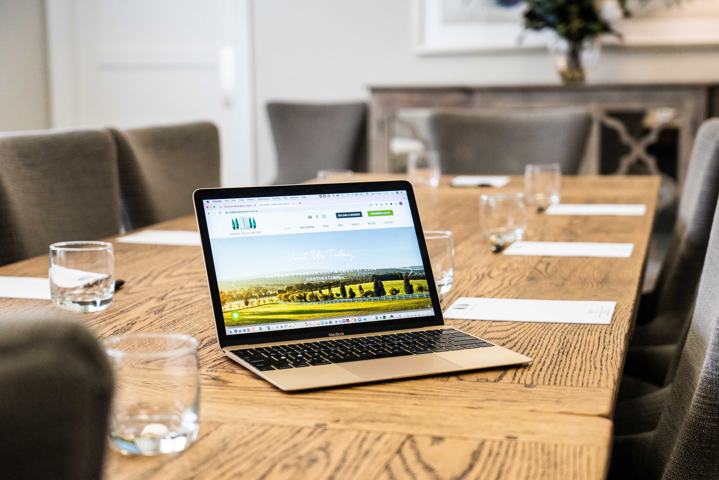 Conference table with a laptop and glasses of water, set for a meeting or presentation.