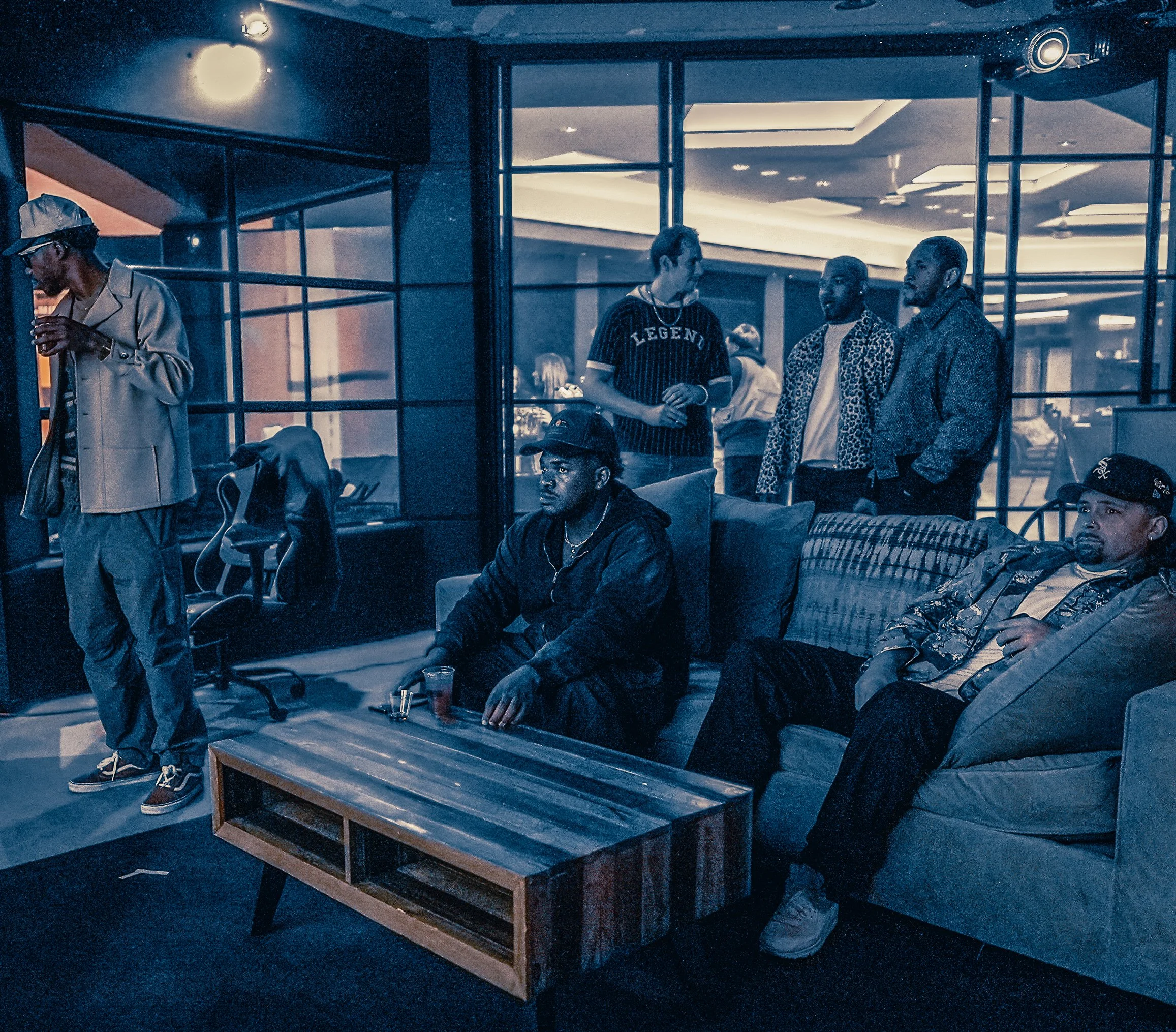 Private artist studio session with musicians and collaborators inside a blue-toned creative lounge setting