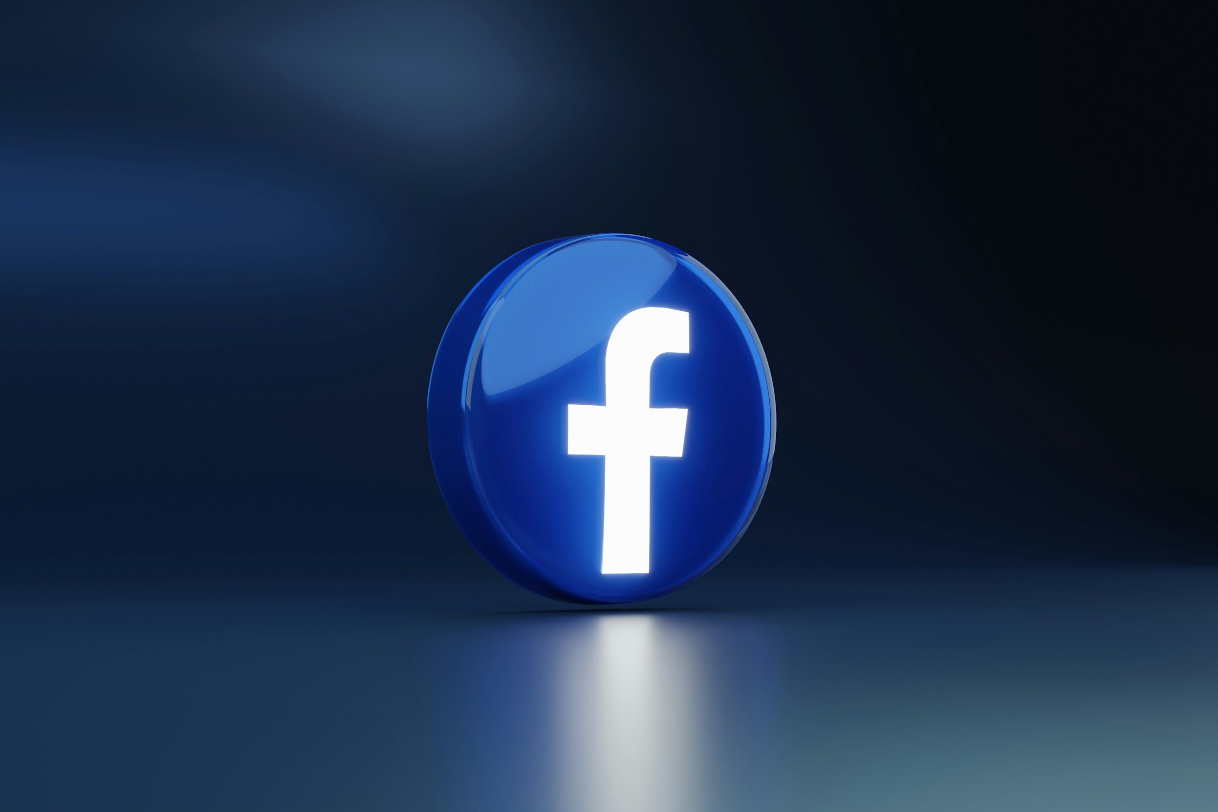 A glowing Facebook logo, which is a white lowercase 'f' on a blue circular background, set against a dark background.