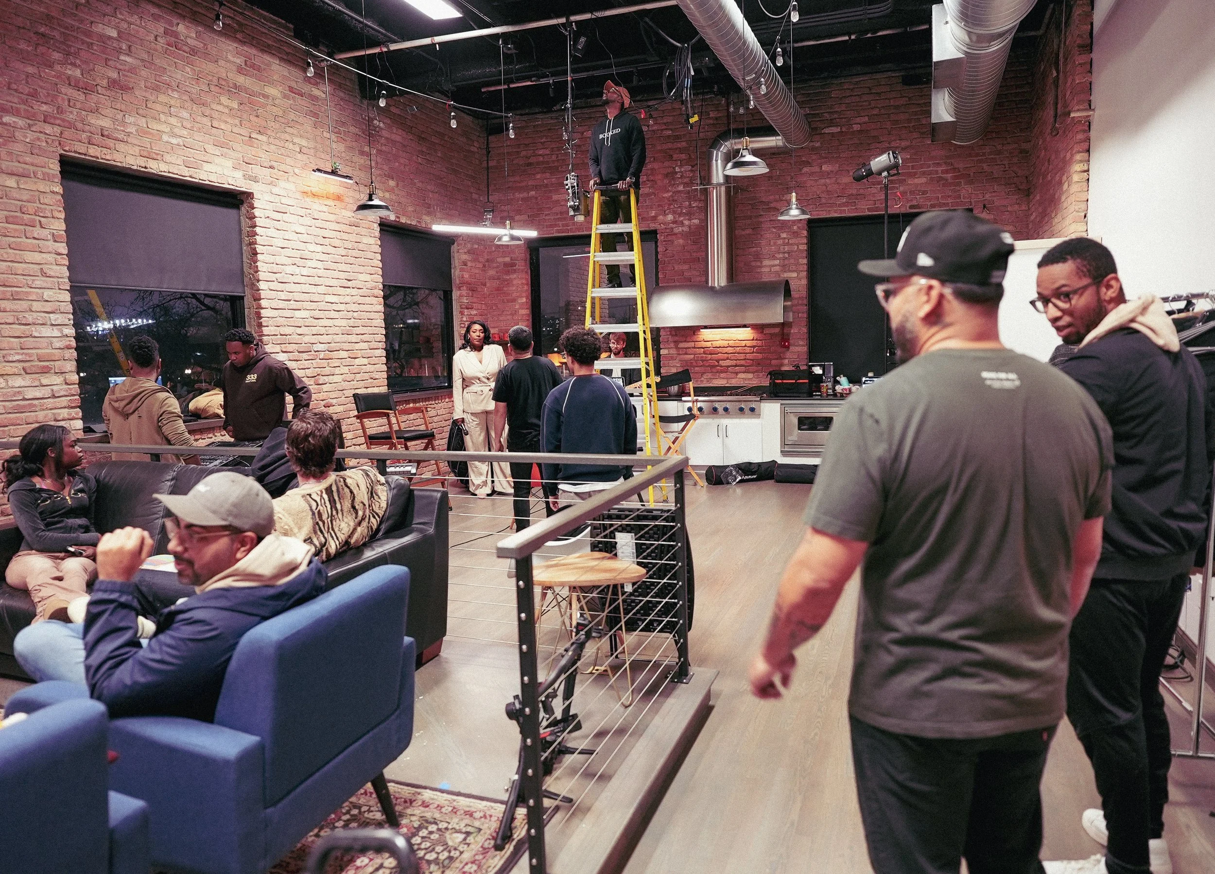 Behind-the-scenes studio setup with ladder, lighting, crew, and production preparation for a Chicago creative event