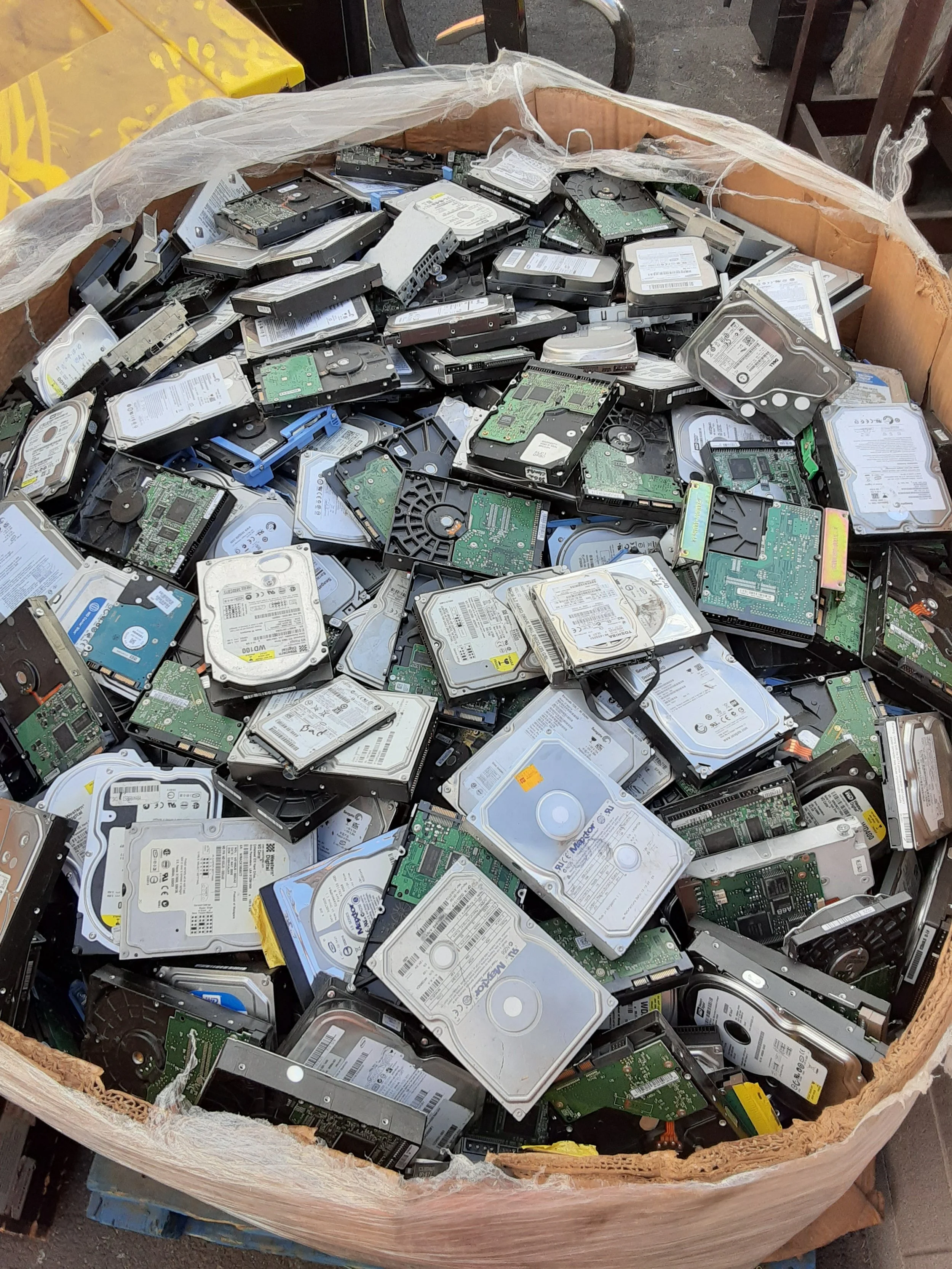 A photo of a gaylord full of scrapped hard drives