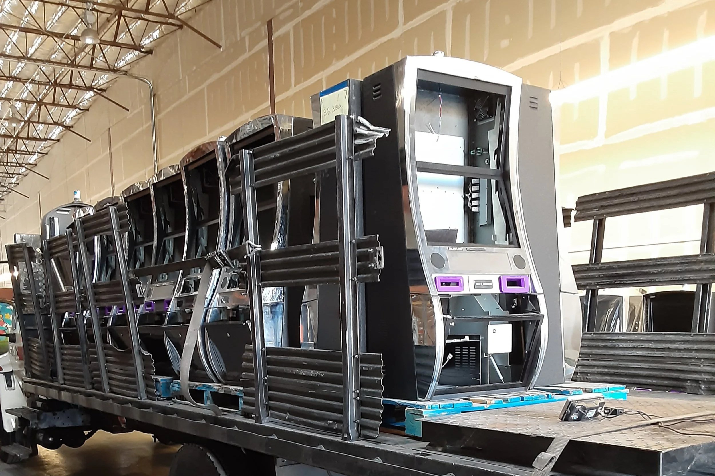 A photo of a group of disassembled slot machines on the back of a stakebed truck.