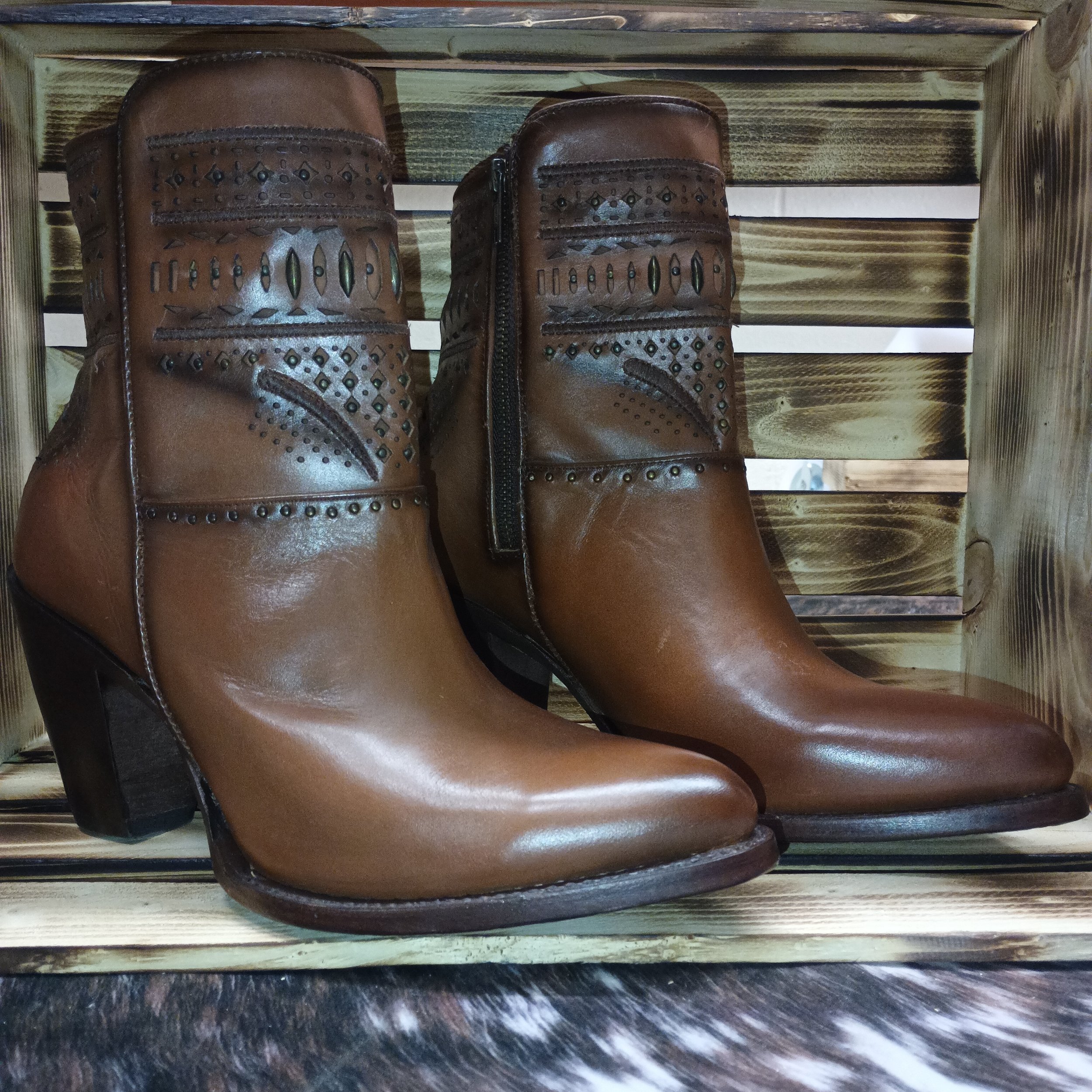 Brown leather western ankle boots with decorative cutout detailing.
