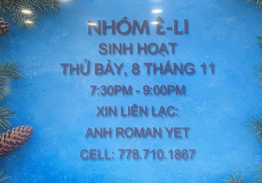 Signboard with blue background and pine branch decorations, displaying information in Vietnamese about a group activity with contact details.