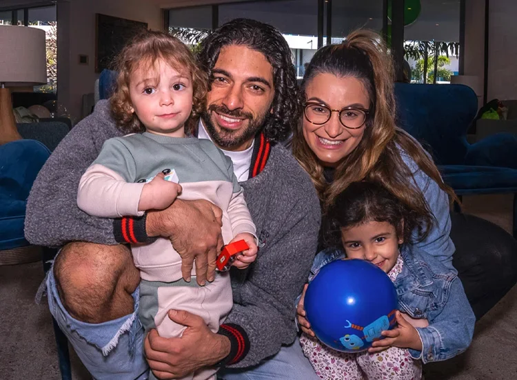 Warm family event photography capturing a family gathered closely together during a birthday celebration, photographed in a natural and candid portrait style.