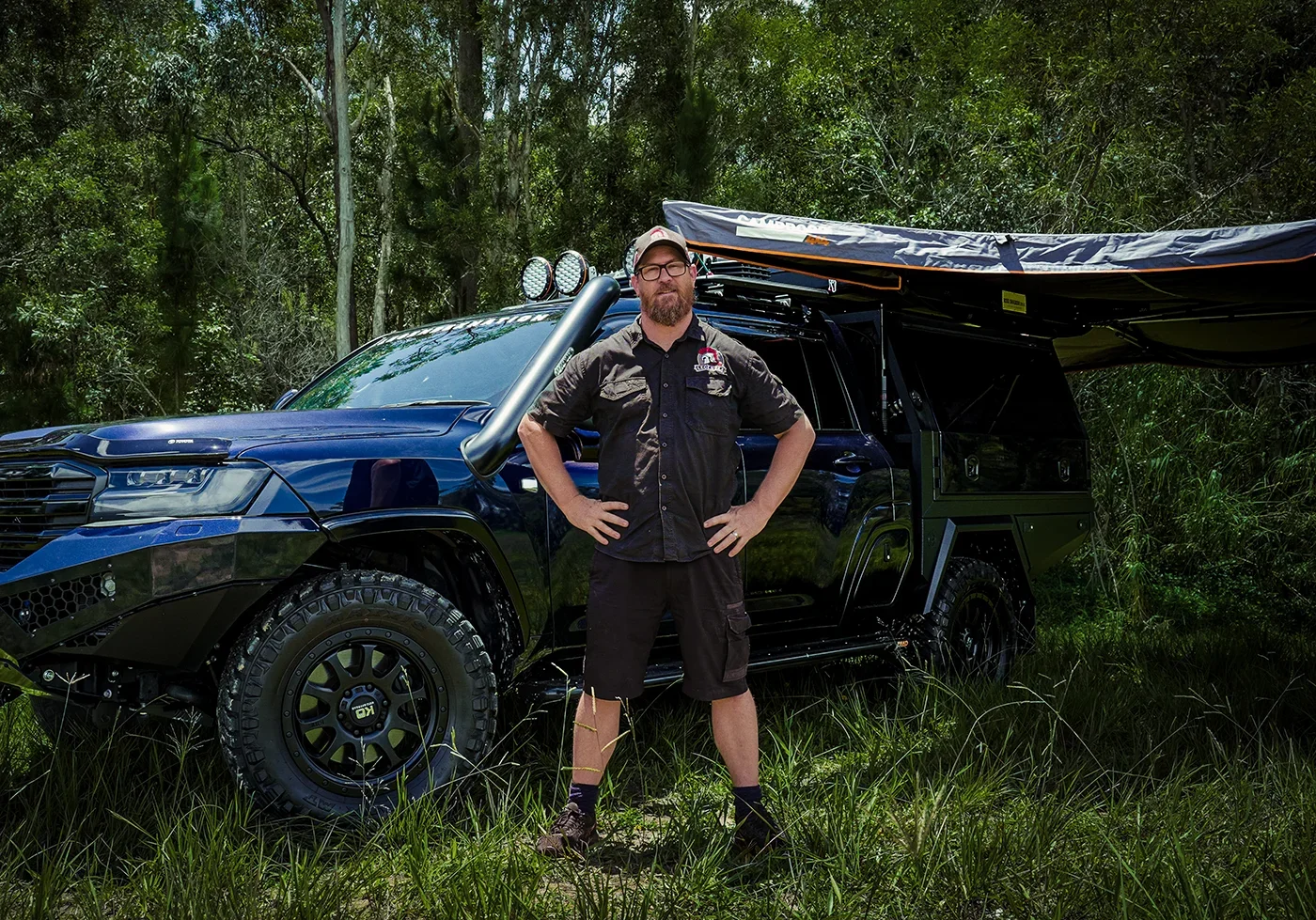 4WD business owner standing beside custom modified vehicle