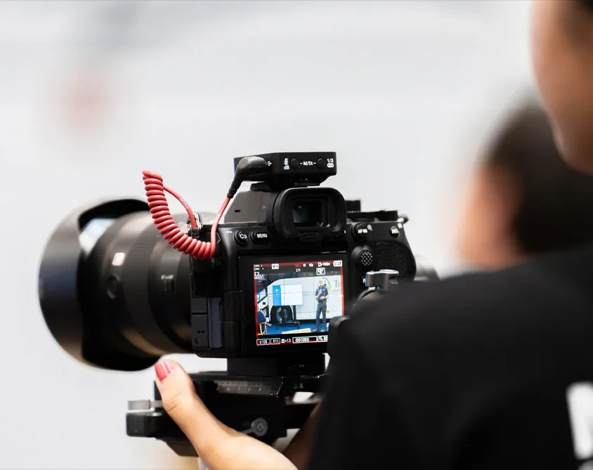 A professional videographer filming on set, operating a high-quality camera during a shoot.