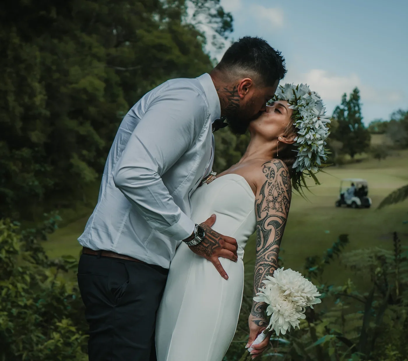 Outdoor wedding photography capturing a bride and groom sharing a romantic kiss in warm golden light, photographed with a natural and cinematic atmosphere.