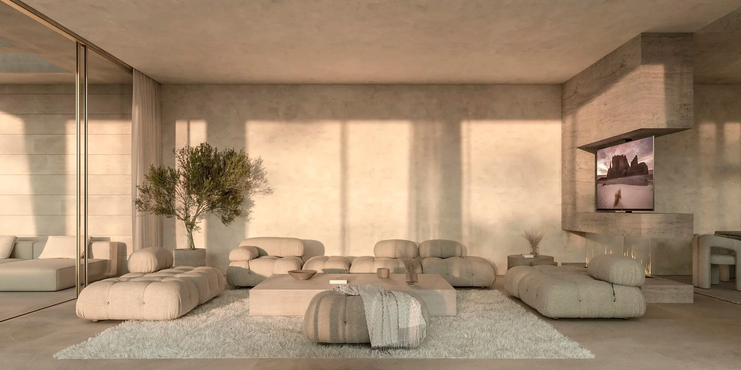 Modern living room with beige sofas, a large wooden coffee table, a potted plant, and a flat-screen TV mounted on a textured wall, illuminated by warm natural light.