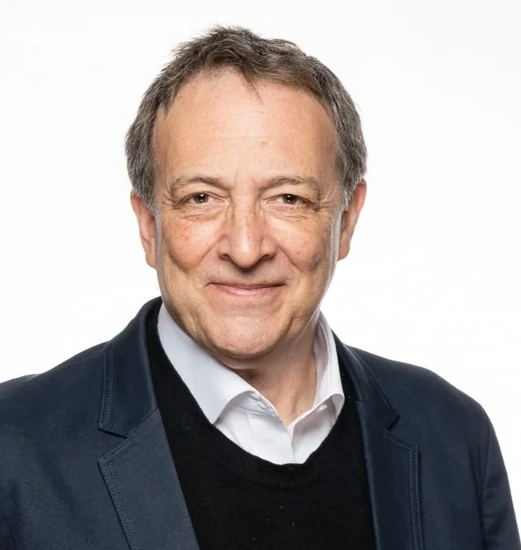 Misha Glenny, author of "McMafia" and "The Cobra Effect", on stage for 92 Speakers delivering keynotes on "Geopolitics and Cyber Insecurity" and the 2026 digital underground.