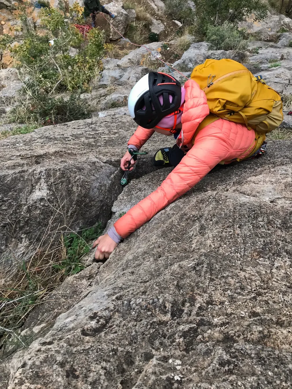 A girl trad climbing in winter around Granada during the second day of a climbing course