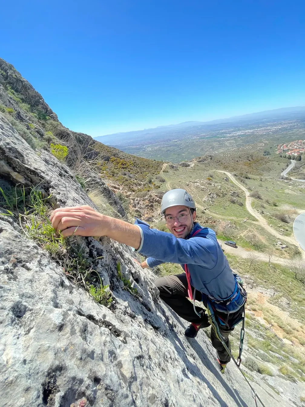 A guys smiling, climbing a multi pitch in Alfacar close to Granada during a multi-pitch course
