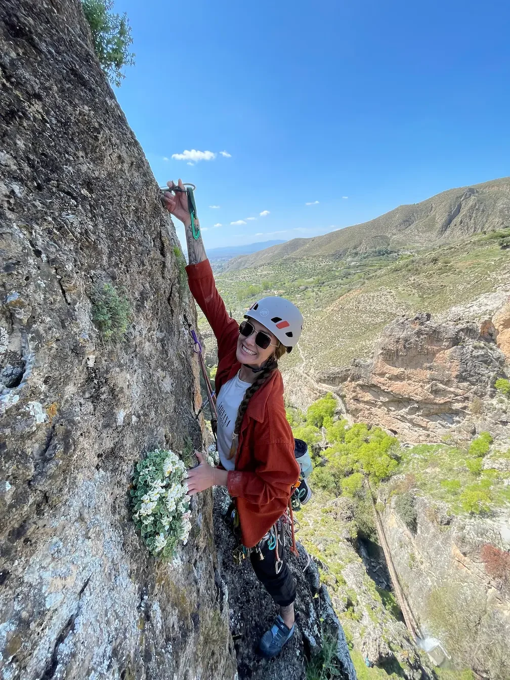 A girl happy, putting a camalot into a crack in Los Cahorros during a Trad Course