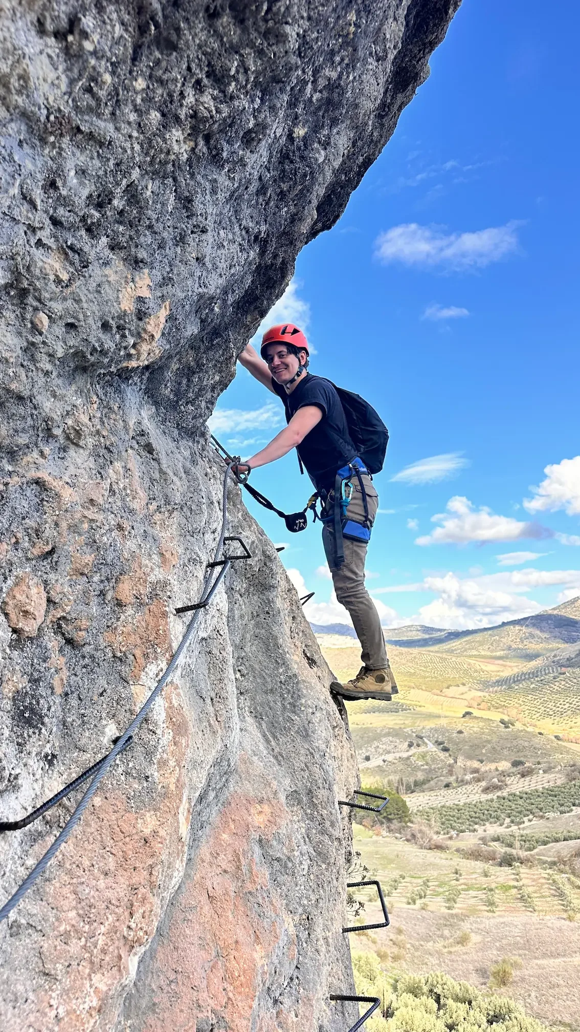 Un homme sourriant se tenant debout sur un barrea de via ferrata en Andalousi