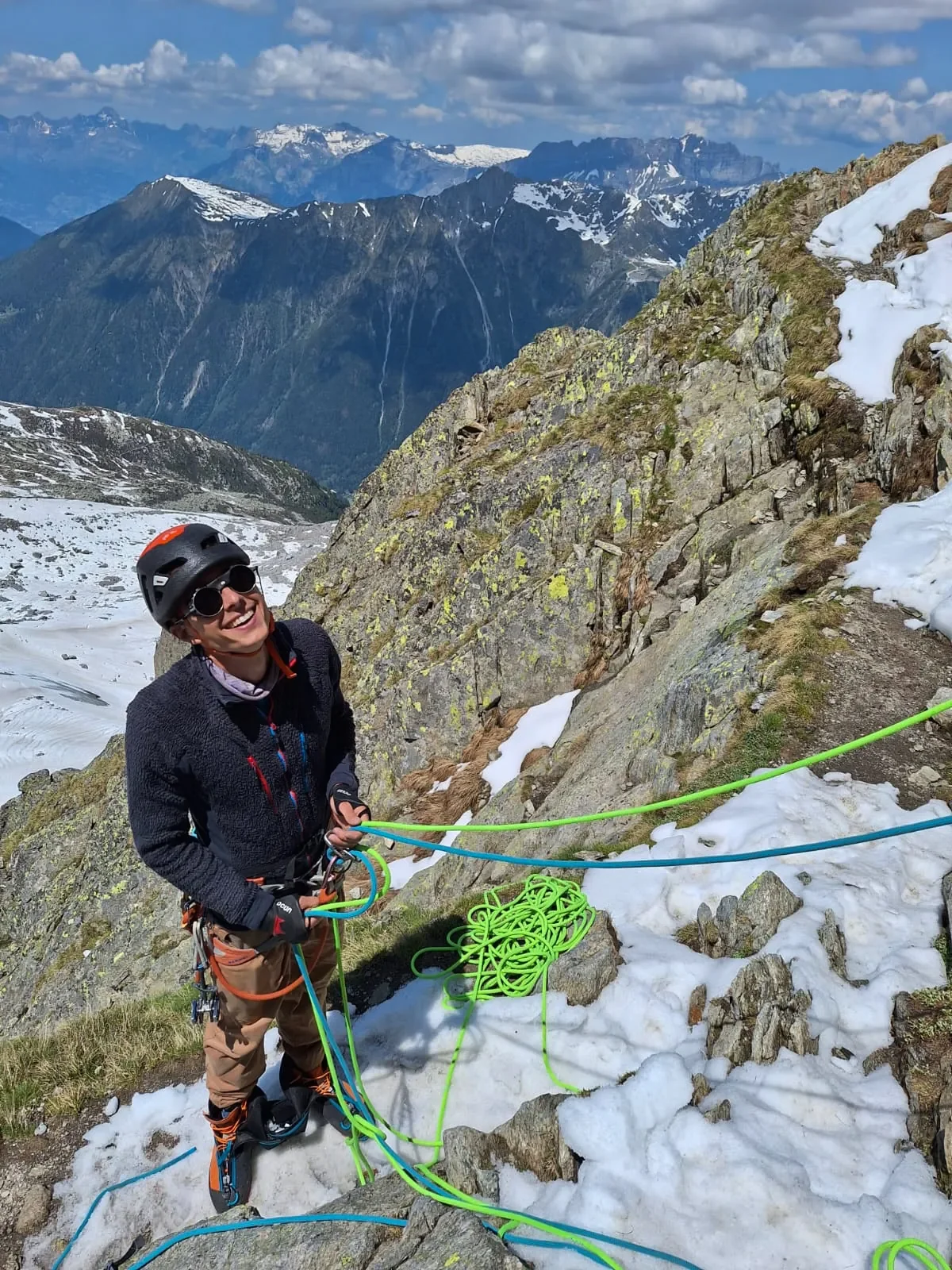 Person rock climbing on a natural limestone cliff with mountain scenery in the background, illustrating outdoor climbing near Granada.