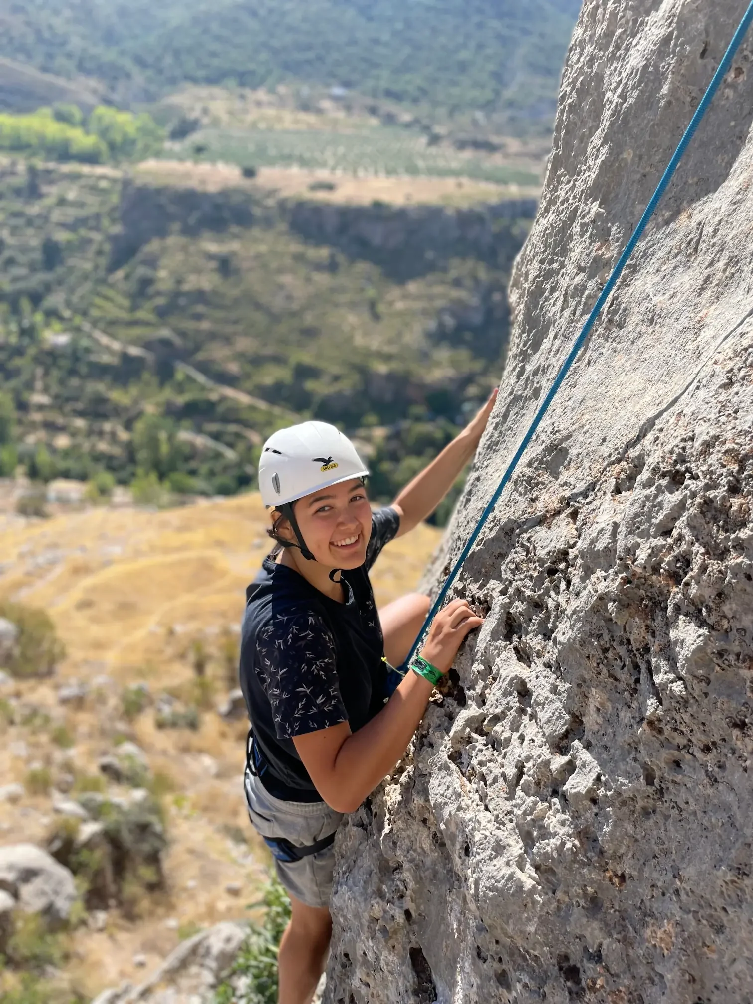 Climber smilling on the rock during her first rock climbing course