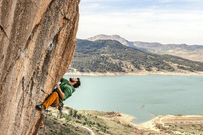 A climber climbing a steep rock face as part of climbing retreat in El Chorro