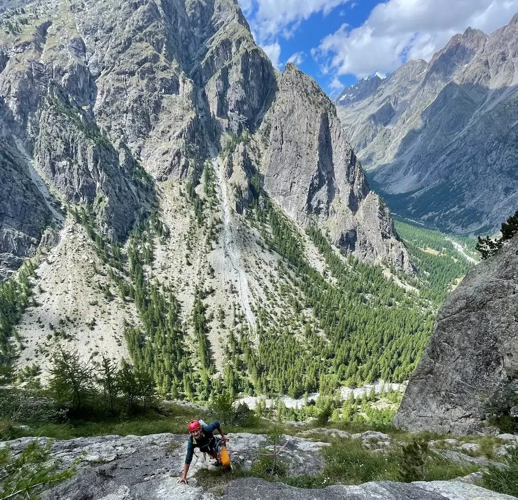 A guy is climbing a multipitch in french alps during an alpin guided multi ptich