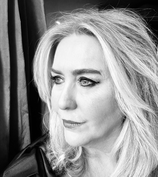 Black and white close-up of a woman with blonde hair looking out a window