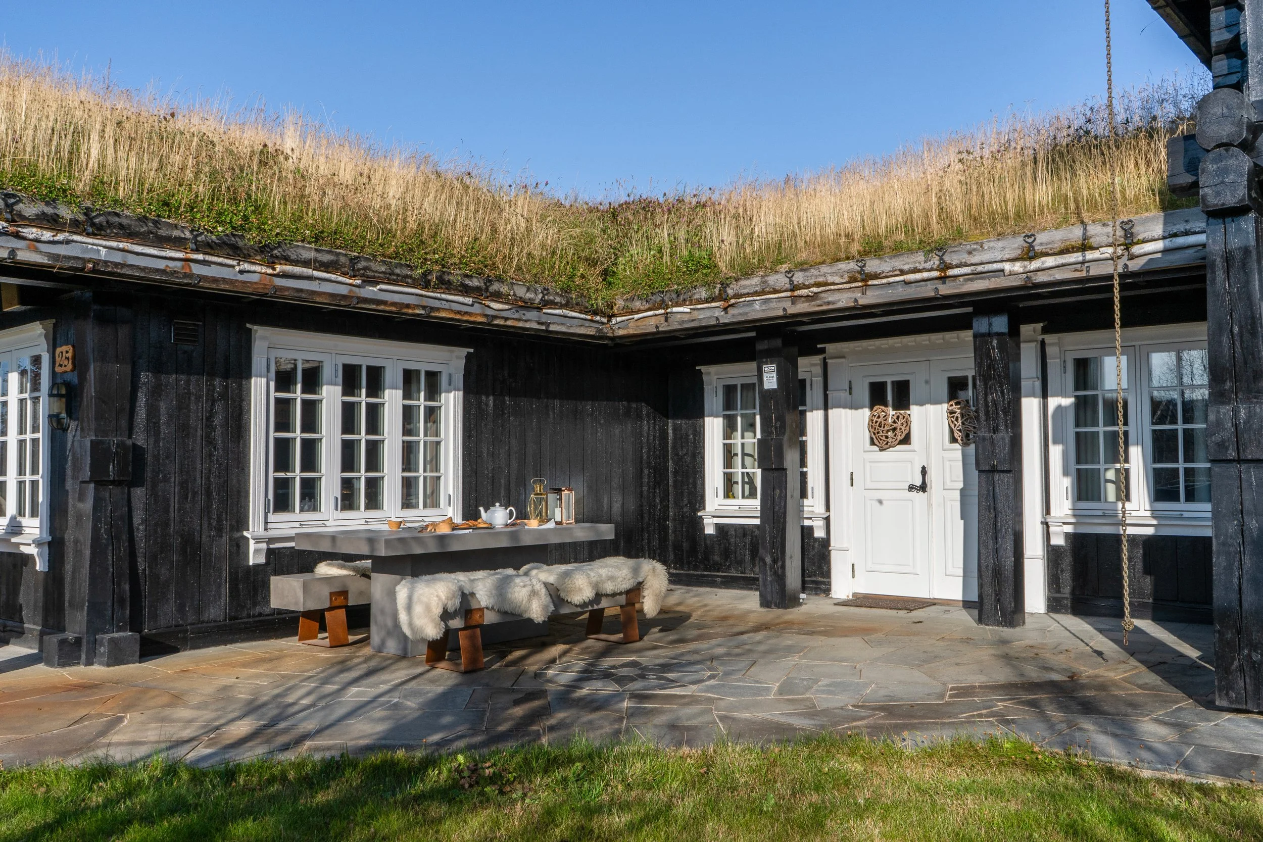 Utendørs sittegruppe foran hytte. Foto