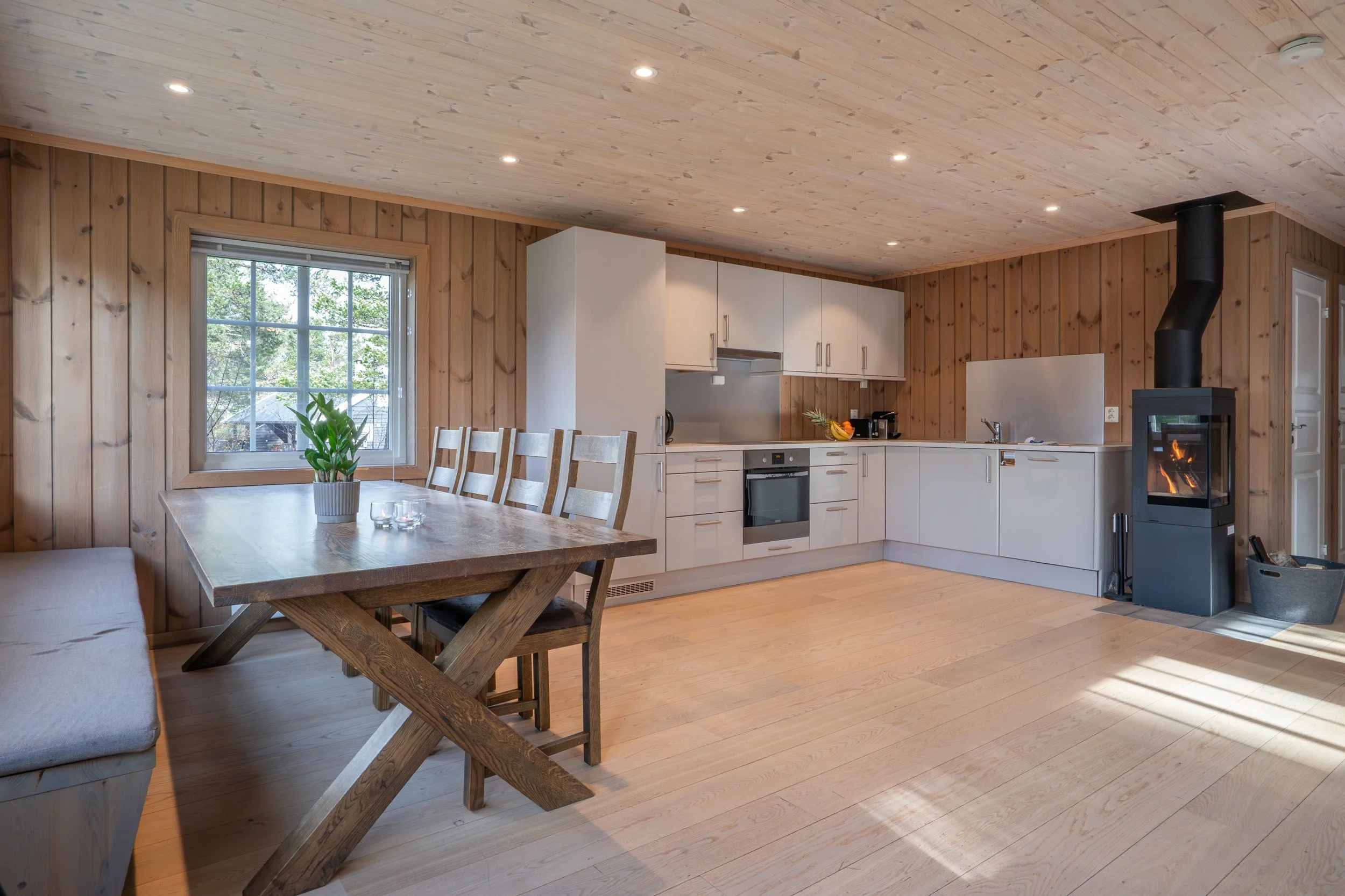 Åpent moderne kjøkken med spisegruppe og peis. Foto