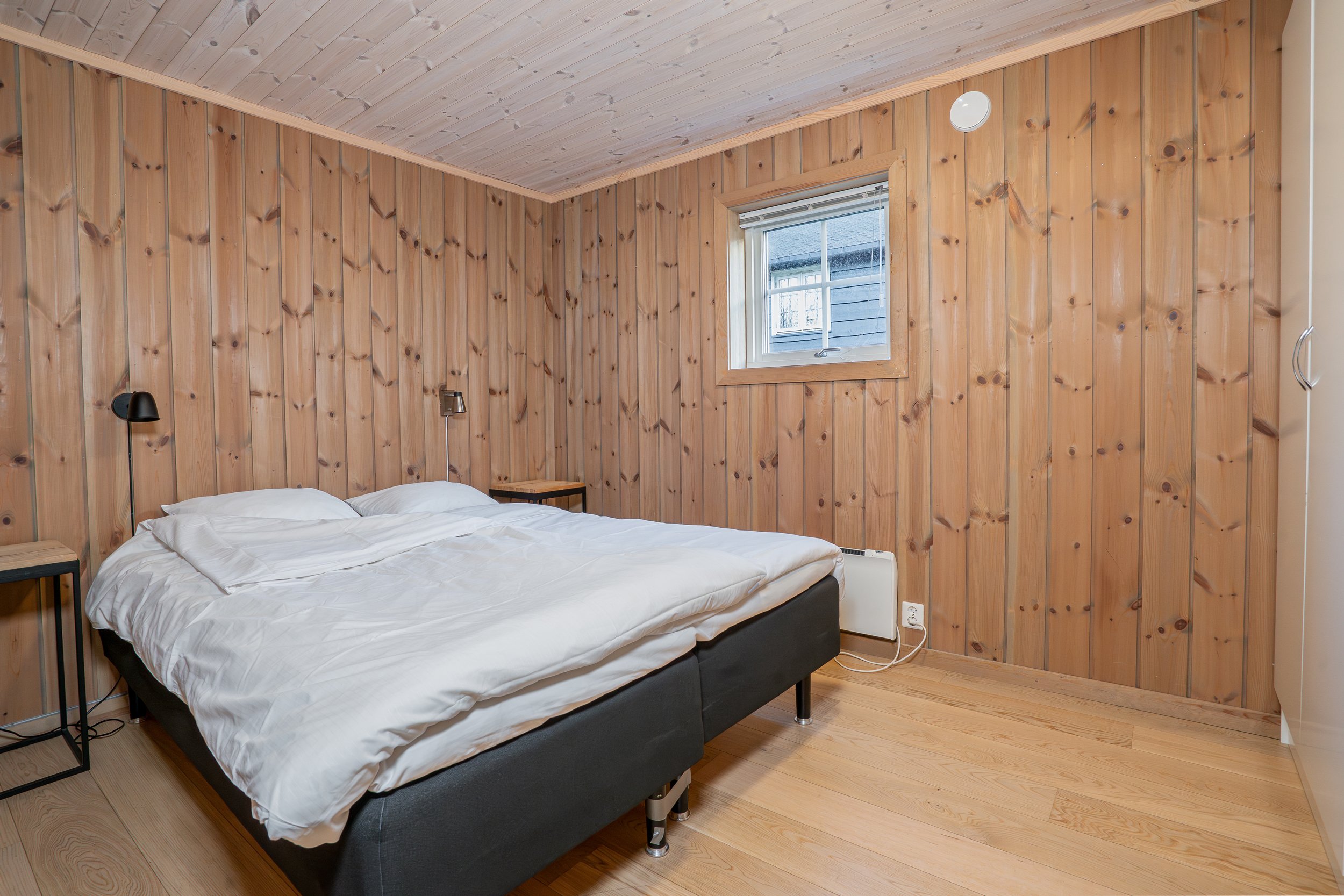Soverom med oppredd dobbeltseng. Foto