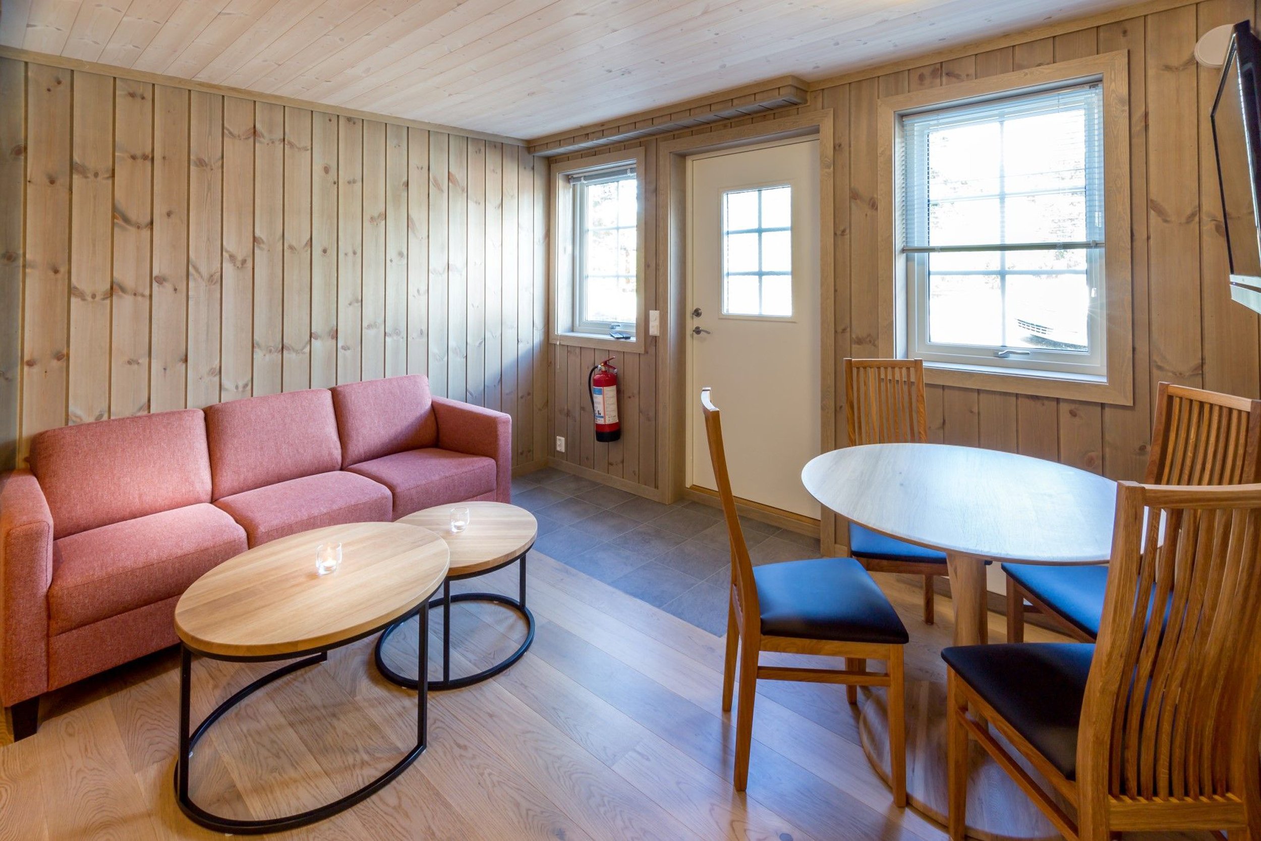 Stue med sofa og spisebord. Inngangsparti i samme område. Foto