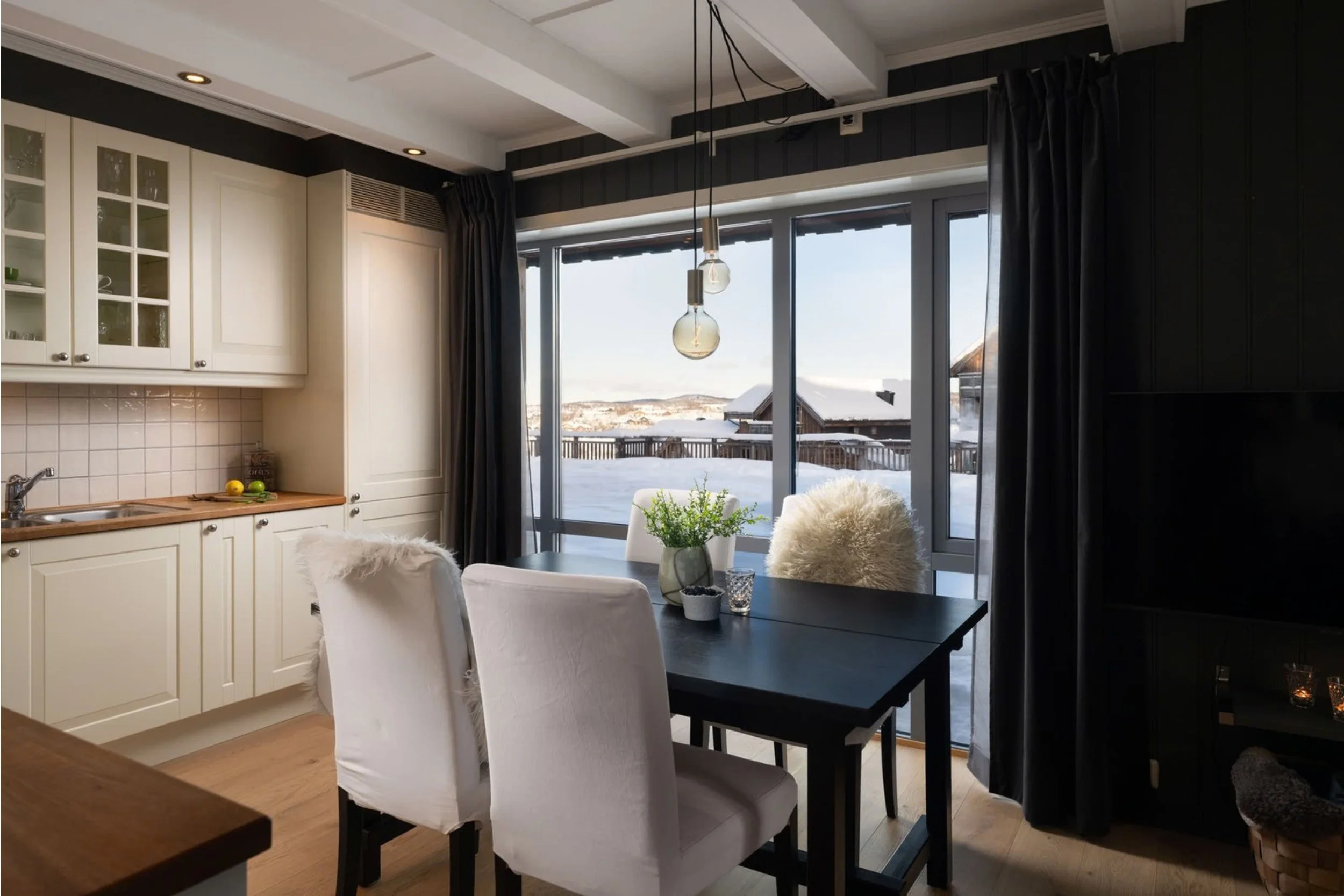 Kjøkken med spisebord, foran stort vindu. Foto
