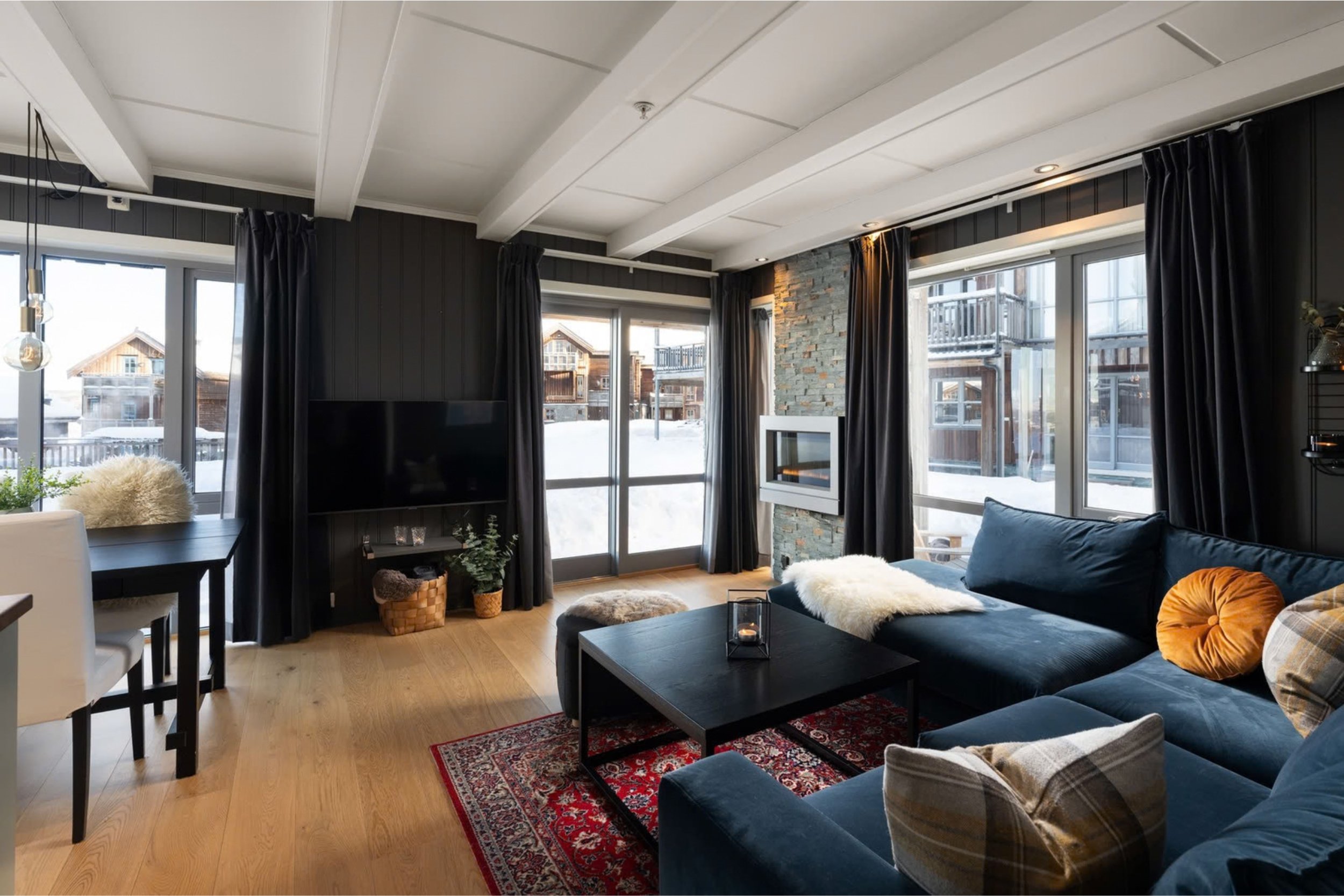 Åpen stue med store vinduer. Foto